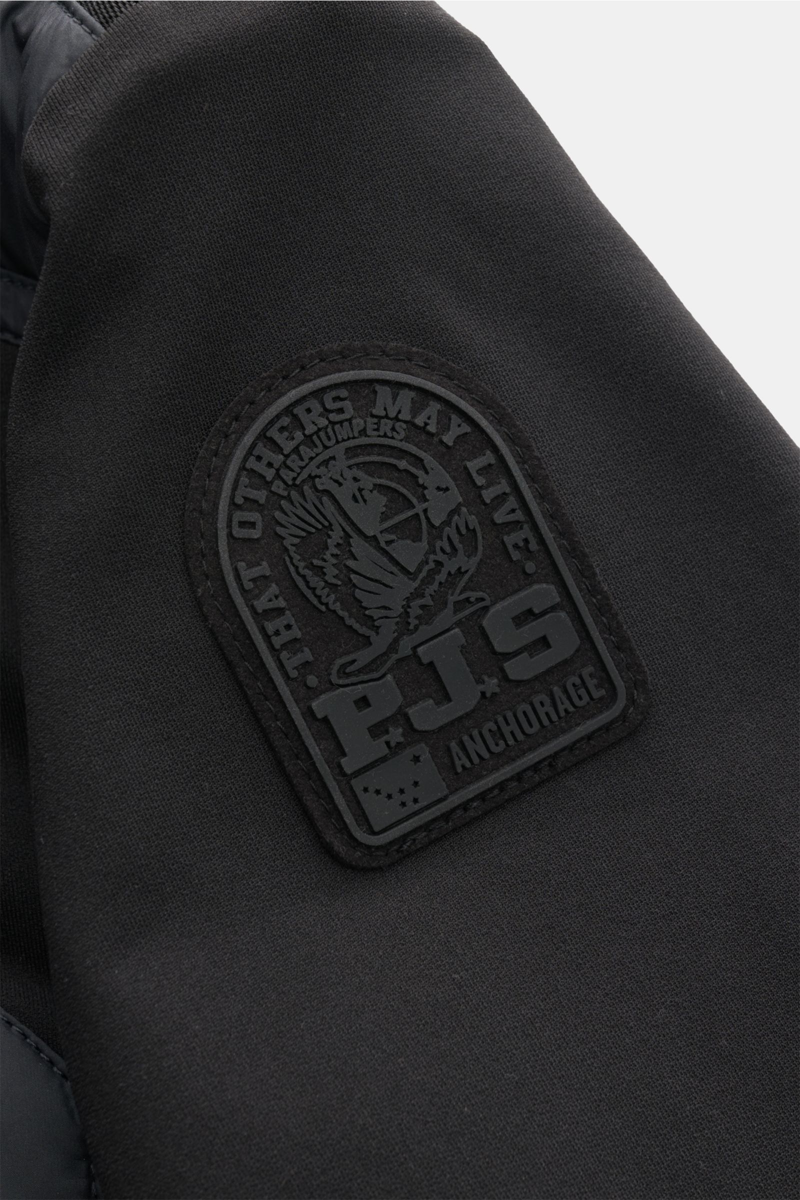 Close-up side view of Parajumpers Jacket 'Douglas' black showing black patch logo on high-quality microfiber fabric.

A functional piece for the transitional season: The jacket 'Douglas' by PARAJUMPERS has a functional, pared down design and can by sty