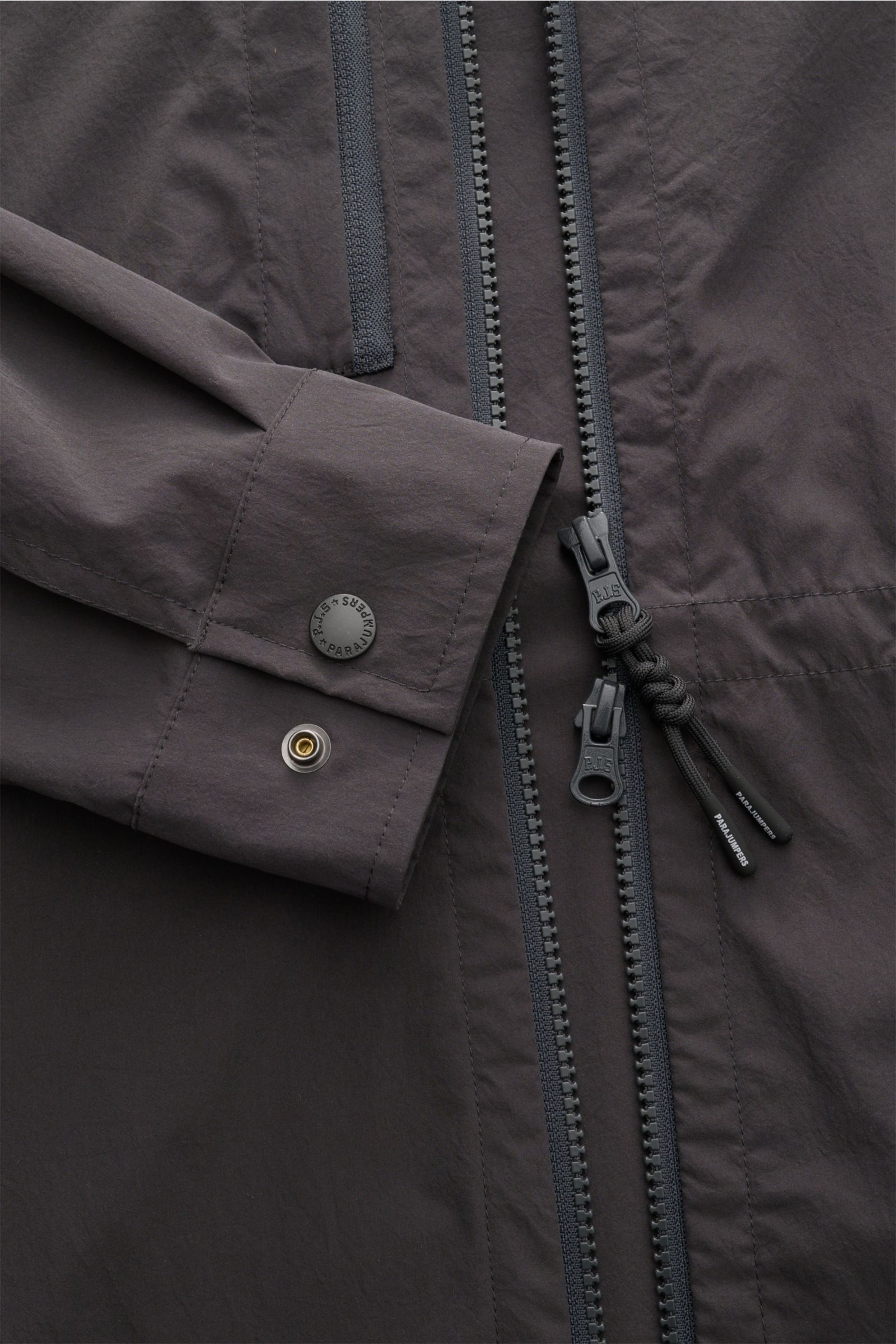 Close-up view of the Parajumpers Jacket 'Inverness' anthracite showing the cuff with button and two-way zip with branded pull cords on crease-free stretchy fabric. Technical sophistication on the move: The hooded jacket 'Inverness' by PARAJUMPERS has a cr