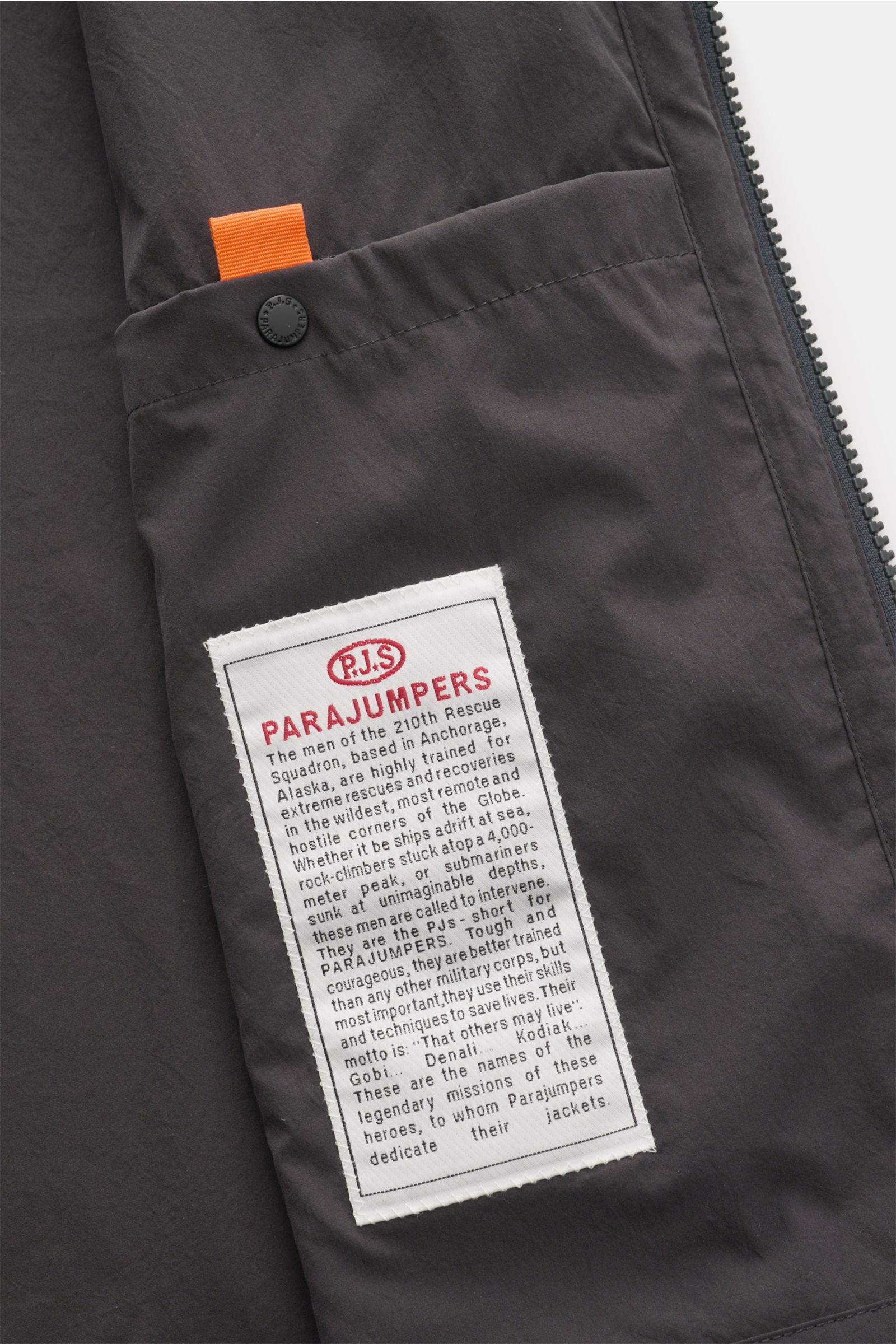Close-up inside view of the Parajumpers Jacket 'Inverness' anthracite showing the inner pocket with signature label and orange tab, highlighting technical features such as crease-free microfibre fabric and slim fit.