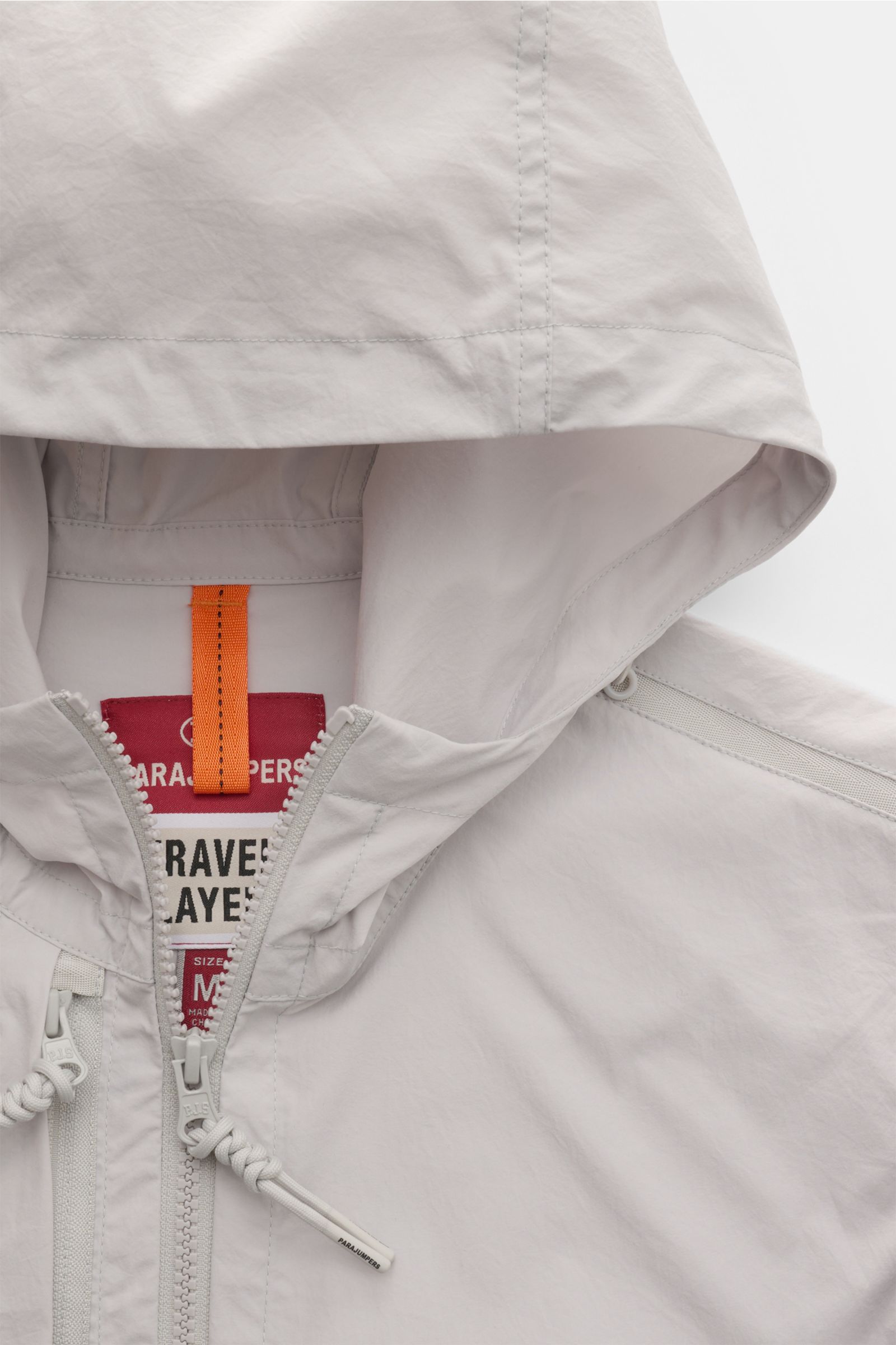 Close-up front view of Parajumpers Jacket 'Inverness' sand, showing crease-free stretchy microfiber fabric, two-way zip, and drawstring hood. Technical sophistication on the move: The hooded jacket 'Inverness' by PARAJUMPERS has a crease-free surface in s