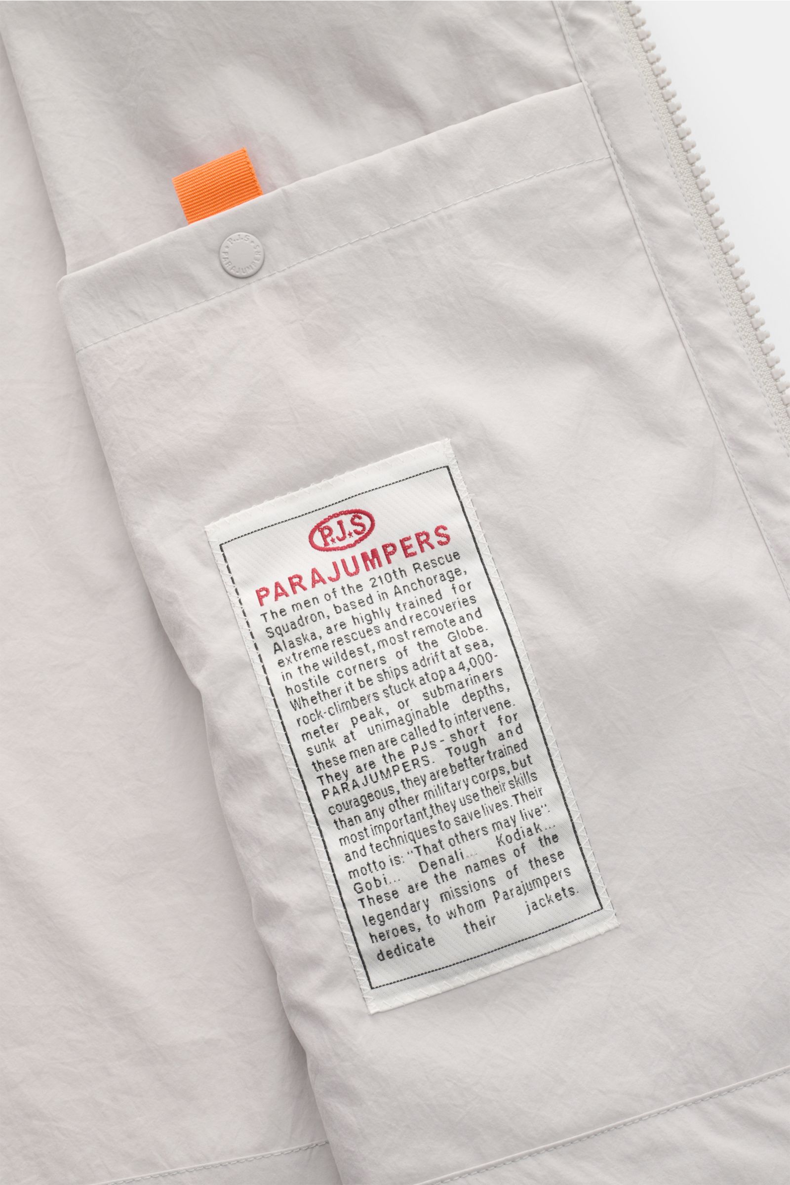 Close-up inside view of the Parajumpers Jacket 'Inverness' sand showing the white fabric with the brand's detailed label and orange pull tab, highlighting technical sophistication on the move with a crease-free surface in stretchy fabric for maximum comfo
