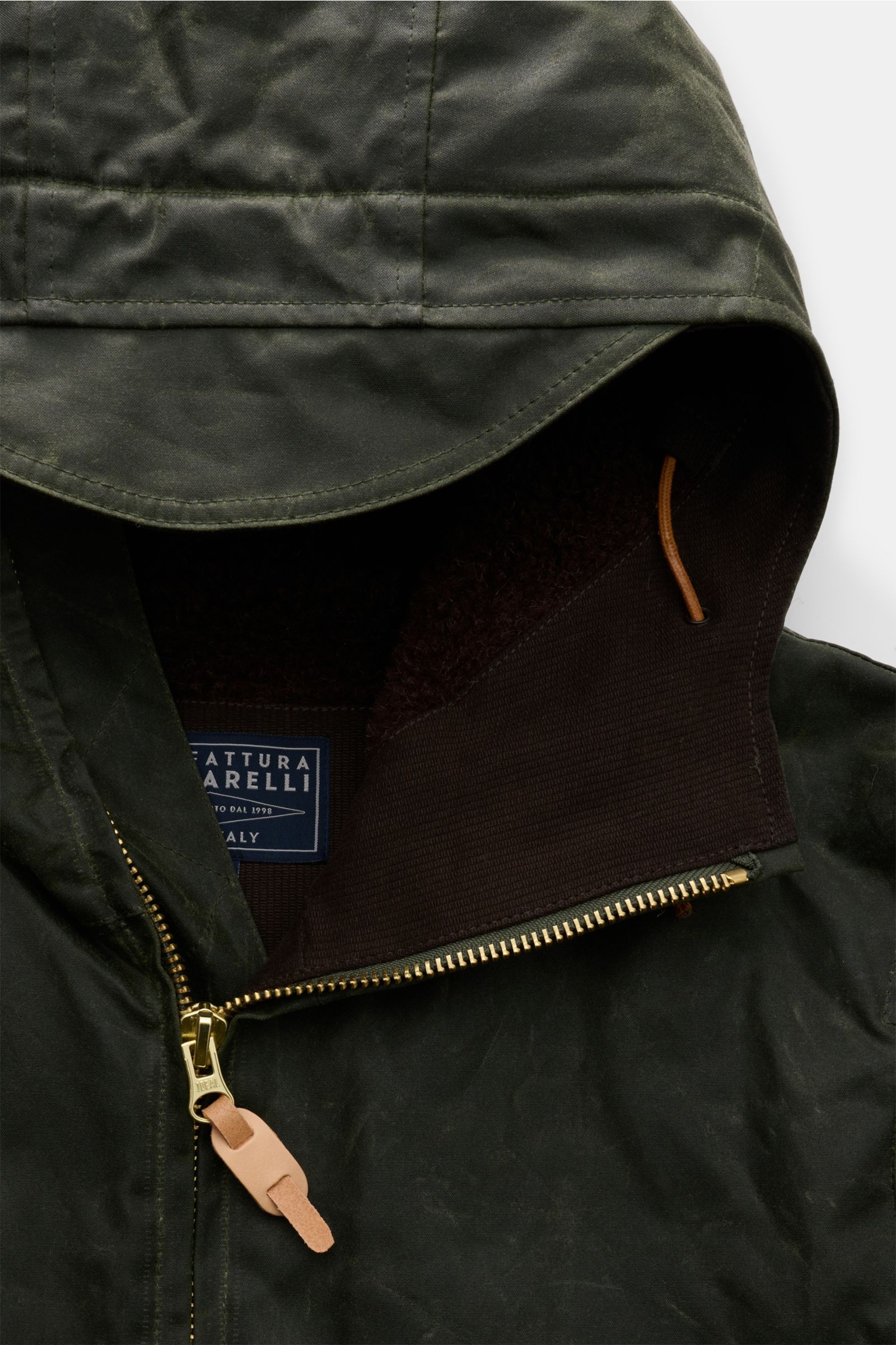 Manifattura Ceccarelli Wachsjacke 'Blazer Coat' dunkelgrün, wasserabweisend, gewachste Baumwolle, Kapuze mit Schirm, Lederdetails, Slim Fit, Zwei-Wege-Reißverschluss, Perspektive von oben auf Kapuze und oberen Reißverschluss.