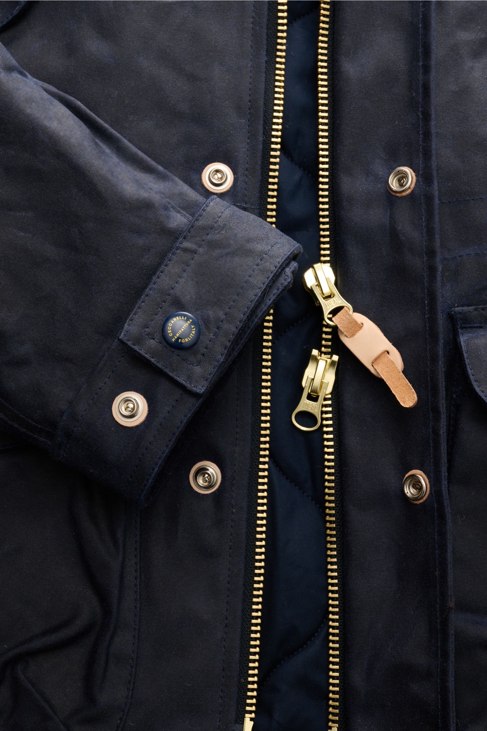 Nahaufnahme der dunkelblauen Manifattura Ceccarelli Wachsjacke 'New Fisherman' navy von vorne mit offenem Zwei-Wege-Reißverschluss, Druckknöpfen und gewachster Baumwolle.