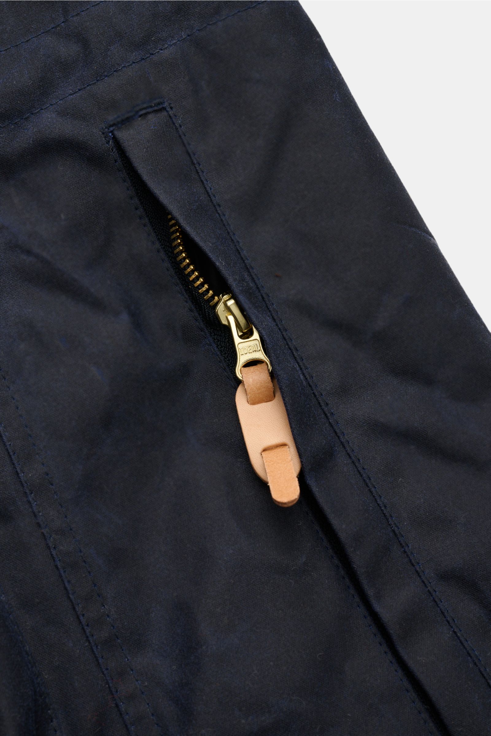 Nahaufnahme der Manifattura Ceccarelli Wachsjacke 'New Fisherman' navy mit gewachster Baumwolle, Reißverschluss und Leder-Zipper-Puller.