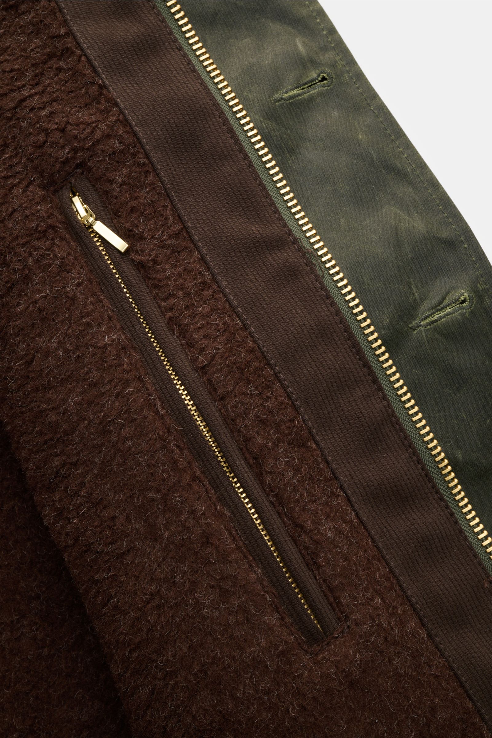 Nahaufnahme der Innenseite der Manifattura Ceccarelli Wachsjacke 'Deck Jacket' dunkelgrün mit Alpakawollfutter und Reißverschluss.