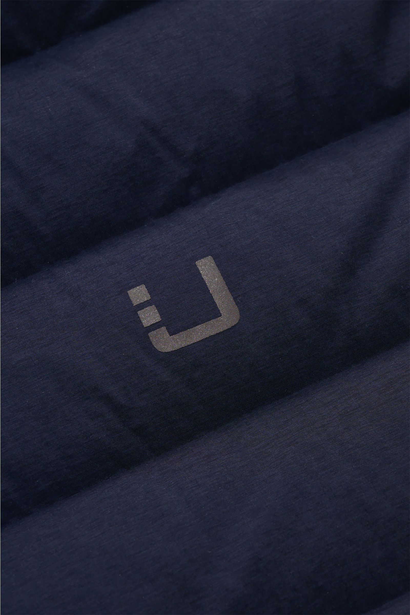 UBR Daunenjacke 'Supersonic' navy Detailaufnahme der wasserabweisenden, elastischen Microfaser mit reflektierendem Logo-Print und verschweißten Nähten.