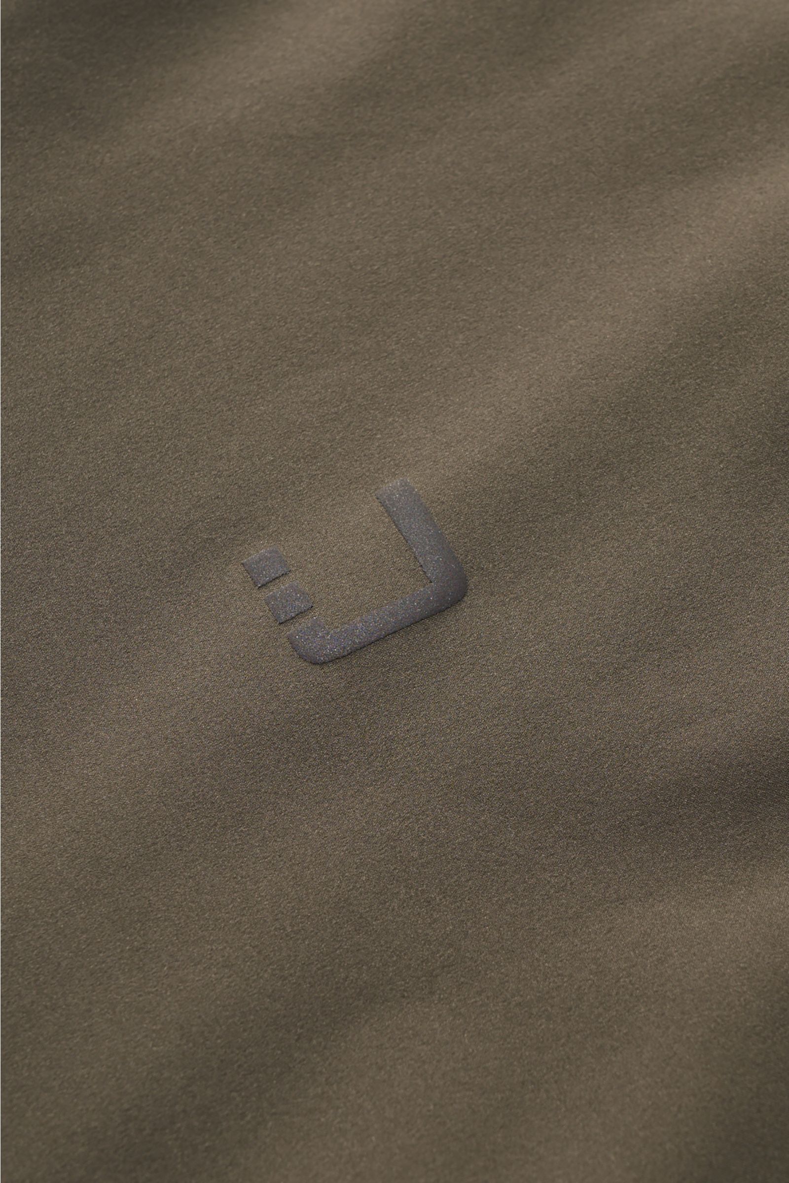 Close-up front view of the UBR Jacket 'Viper' grey-green, showcasing its high-quality, stretchy microfiber with a soft, smooth feel and reflective logo print. UBR are the experts when it comes to the finest materials and innovative manufacturing technique