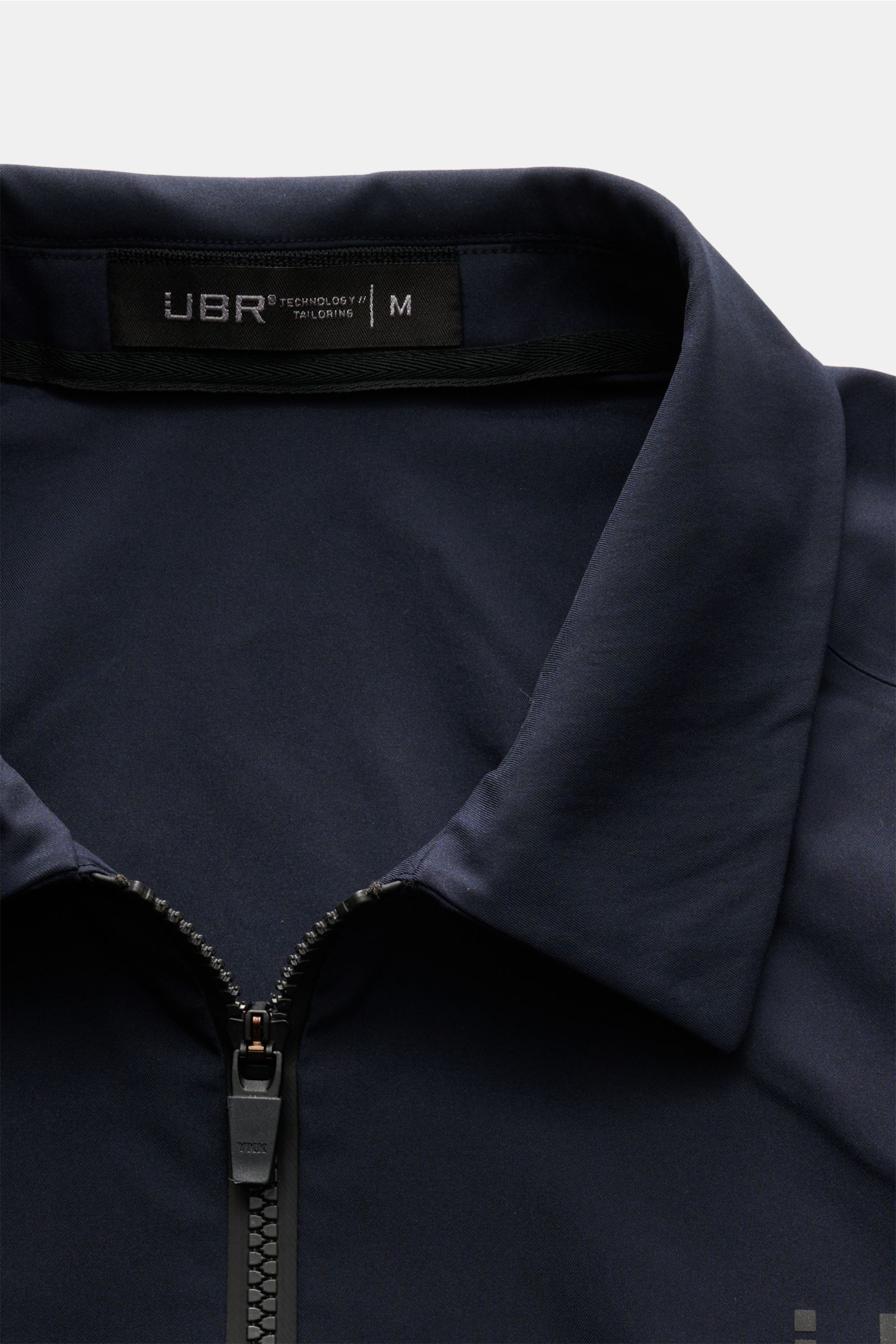 UBR Jacke 'Nano' navy in Nahaufnahme von oben mit Umlegekragen, Zwei-Wege-Reißverschluss, hochwertiger, glatter Microfaser, wind- und wasserabweisend.