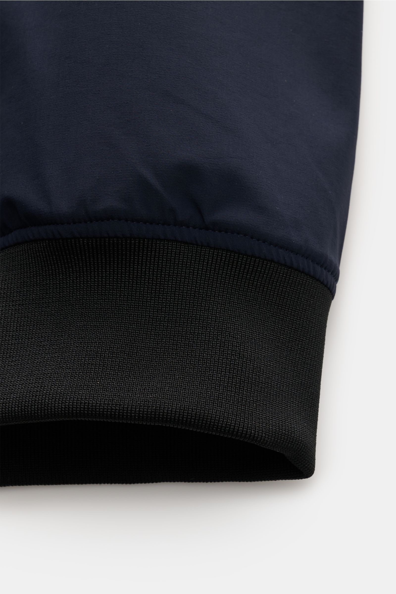 UBR Blouson 'Delta' navy close-up of sleeve cuff from front, showing elastic black ribbed hem and smooth navy microfiber fabric 