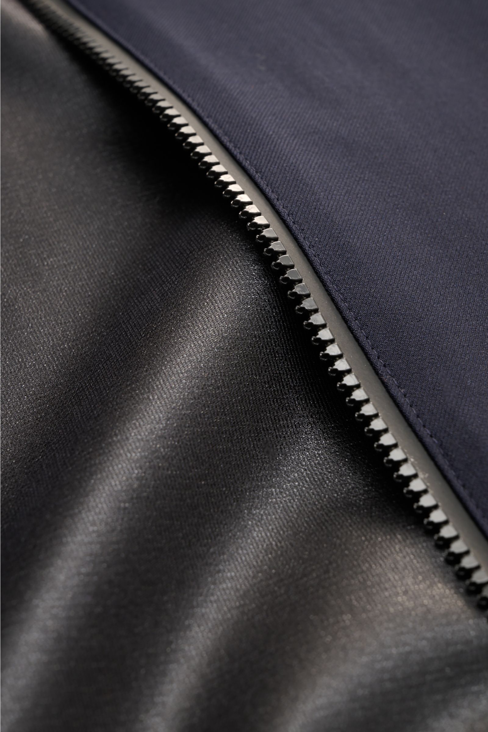 Close-up front-side view of the navy zipper and fabric texture of the UBR Blouson 'Bullet Savile' navy, minimalist and functional.