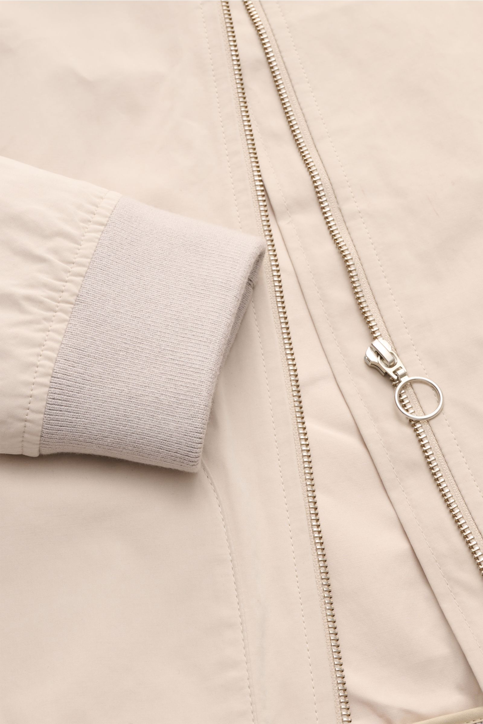 Nahaufnahme des Reißverschlusses und des Ärmelbündchens des beigen 04651/ A trip in a bag Blouson 'Peached Cotton' mit softem Baumwoll-Microfaser-Mix.