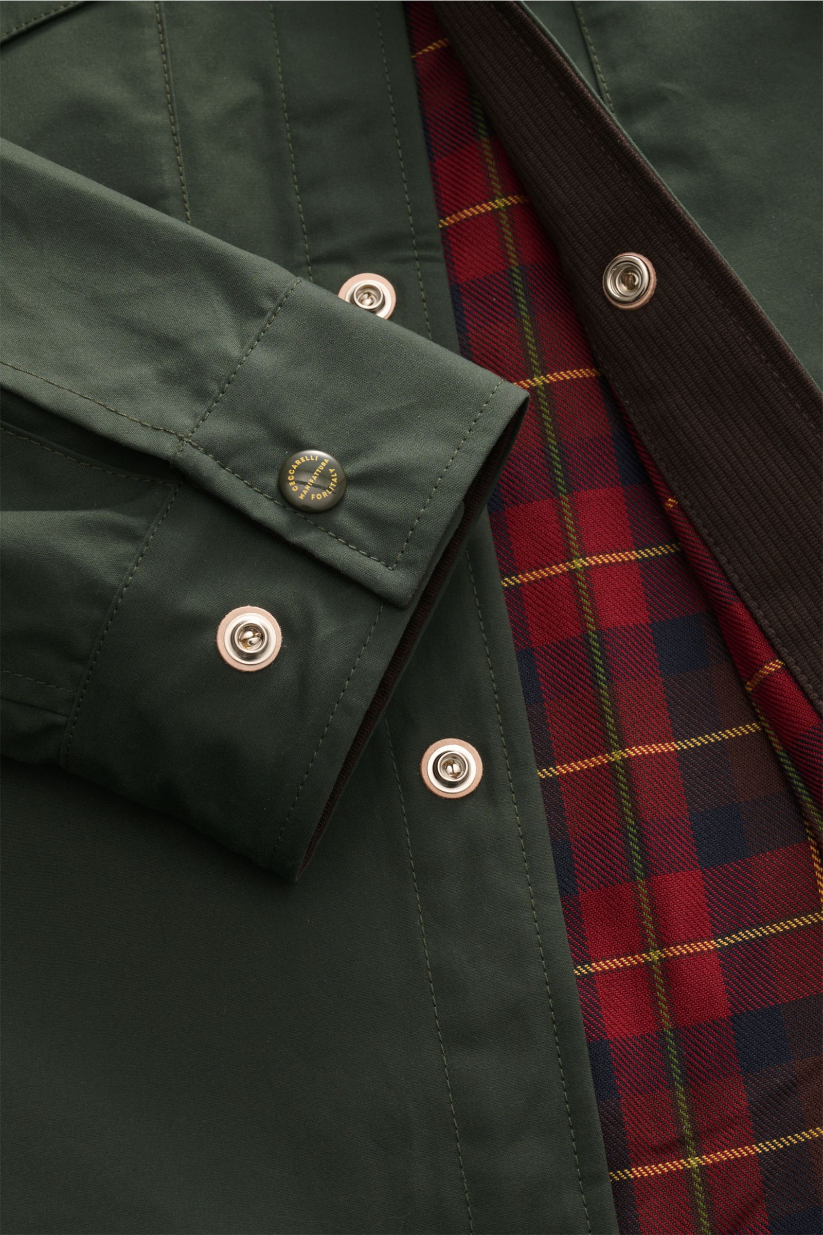 Manifattura Ceccarelli Wachsjacke 'Heavy Shirt' dunkelgrün in Nahaufnahme von vorne mit gewachster, wasserabweisender Baumwolle, Druckknopfleiste und rotem Tartan-Futter.