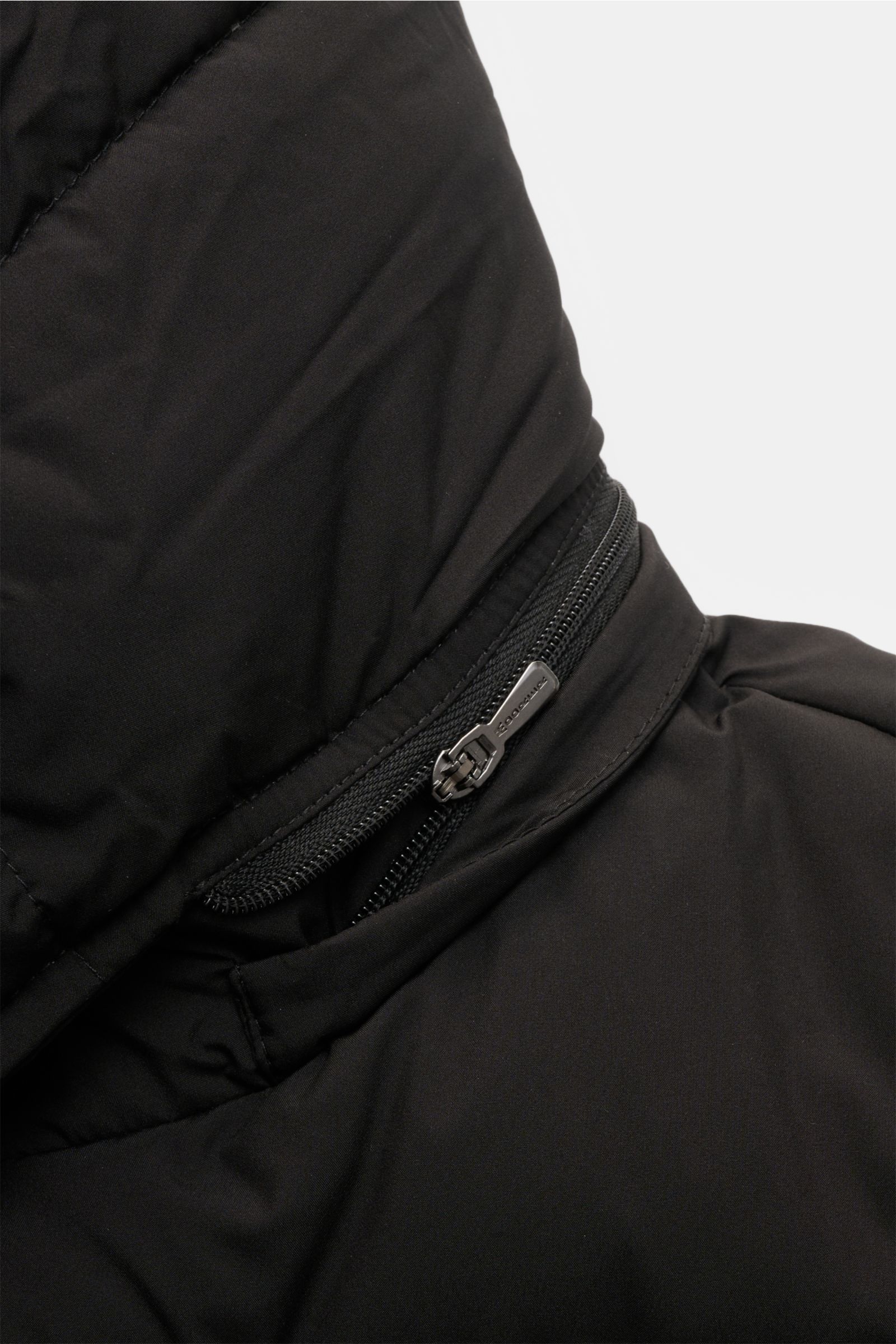 Nahaufnahme der abnehmbaren Kapuze mit Zwei-Wege-Reißverschluss der Moorer Daunenjacke 'Brett' schwarz aus hochwertiger Microfaser, wasserabweisend und mit wärmender Daunenfüllung.