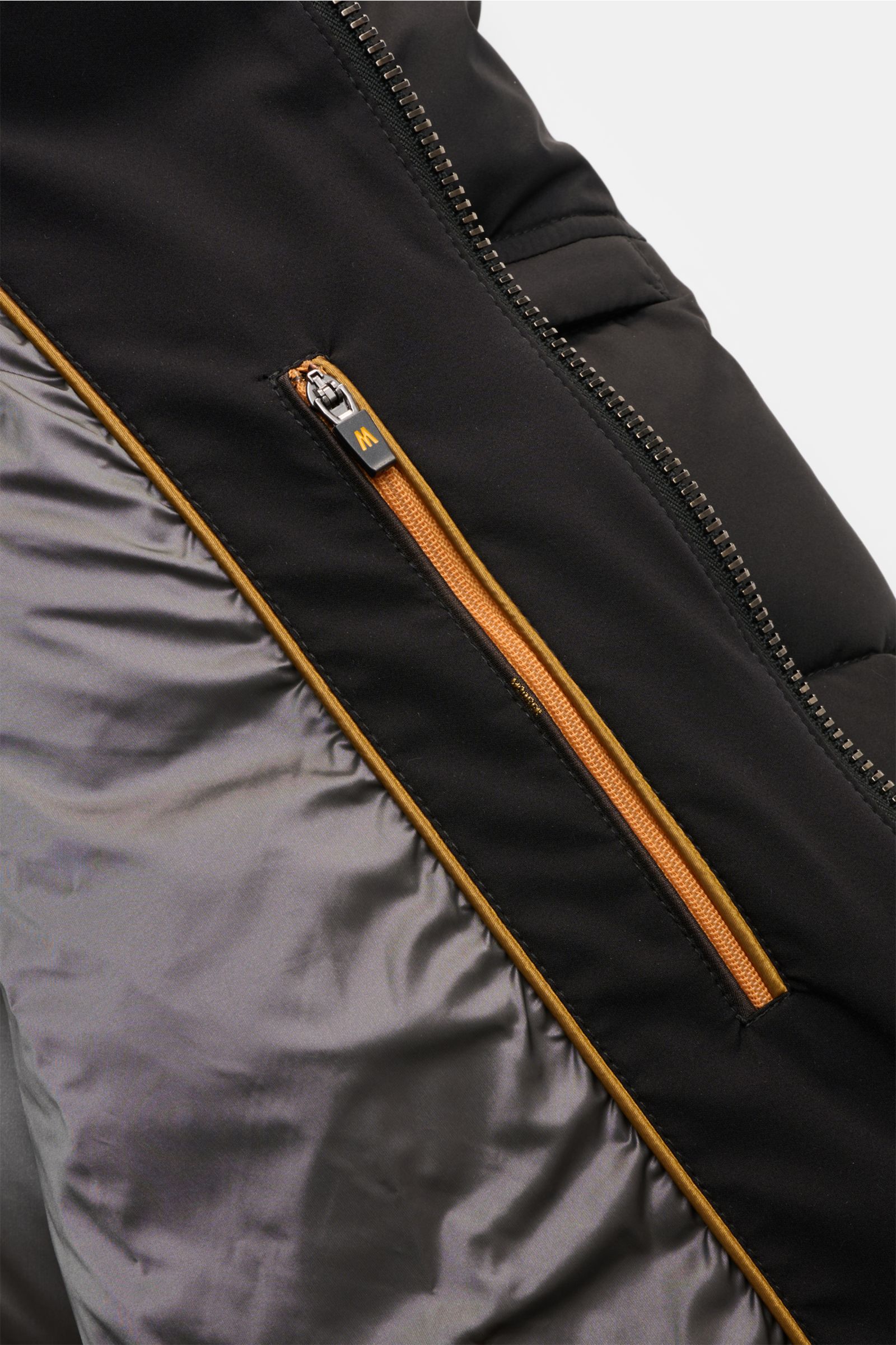 Nahaufnahme der Moorer Daunenjacke 'Brett' schwarz von innen mit glattem Futter, wasserabweisendem Außenstoff und Reißverschluss-Tasche.