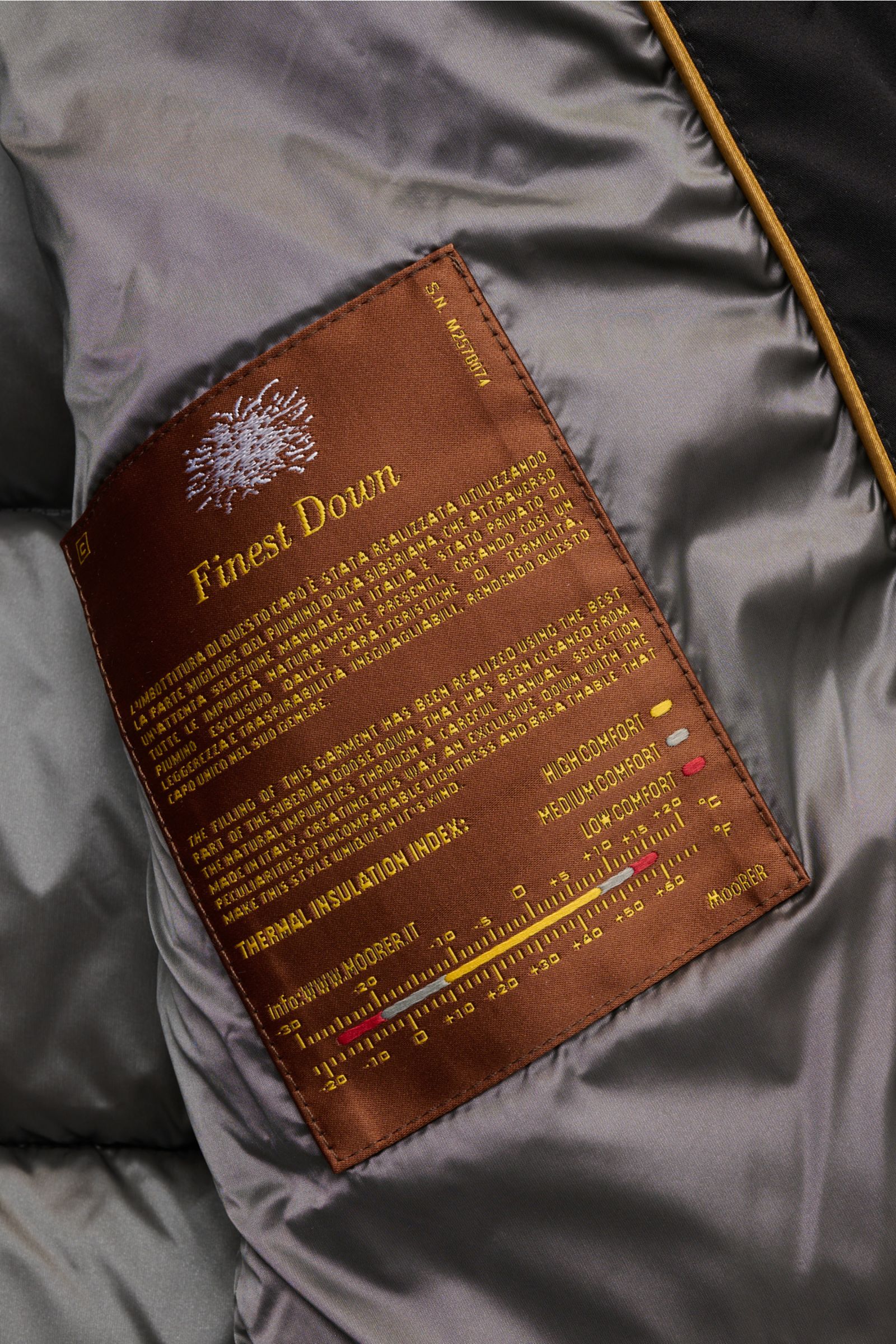 Innenansicht der Moorer Daunenjacke 'Brett' schwarz mit braunem Finest Down Label, glattem Futter und hochwertiger Daunenfüllung.