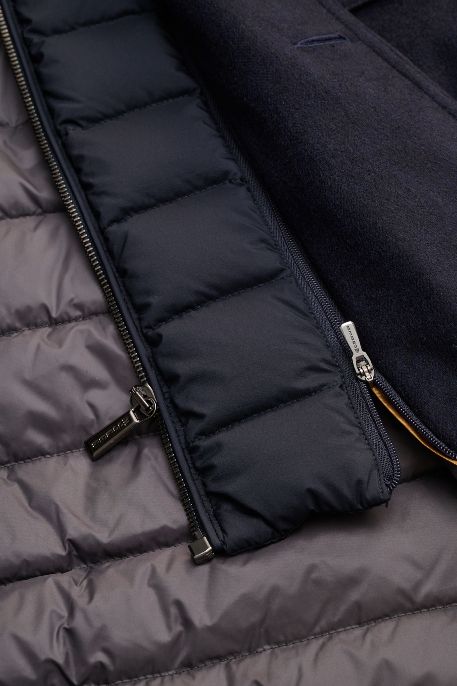 Nahaufnahme der Innenansicht der Moorer Daunenjacke 'Monti' navy mit herausnehmbarer, leichter Daunenfüllung, Reißverschlüssen und gesteppter Innenausstattung.