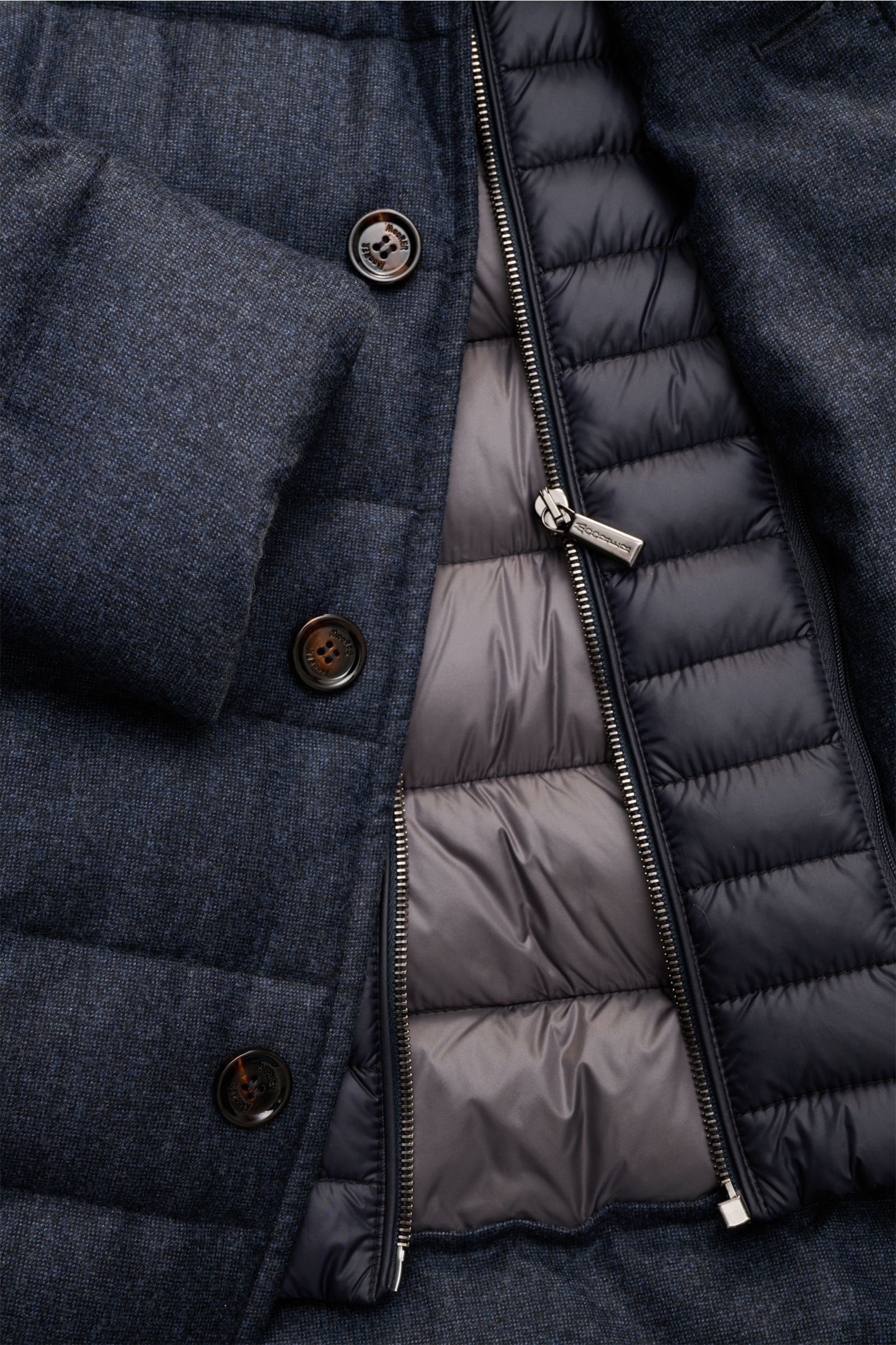 Nahaufnahme der Moorer Daunenjacke 'Nomos' dark navy meliert von vorne, zeigt reine Wolle, weichen Griff, Gänsedaunenfüllung, Slim Fit, herausnehmbare Double-Front mit Zipper, drei Knöpfe, Reverskragen, Brust- und Hüfttaschen, kleines Weblabel, geschmeidi