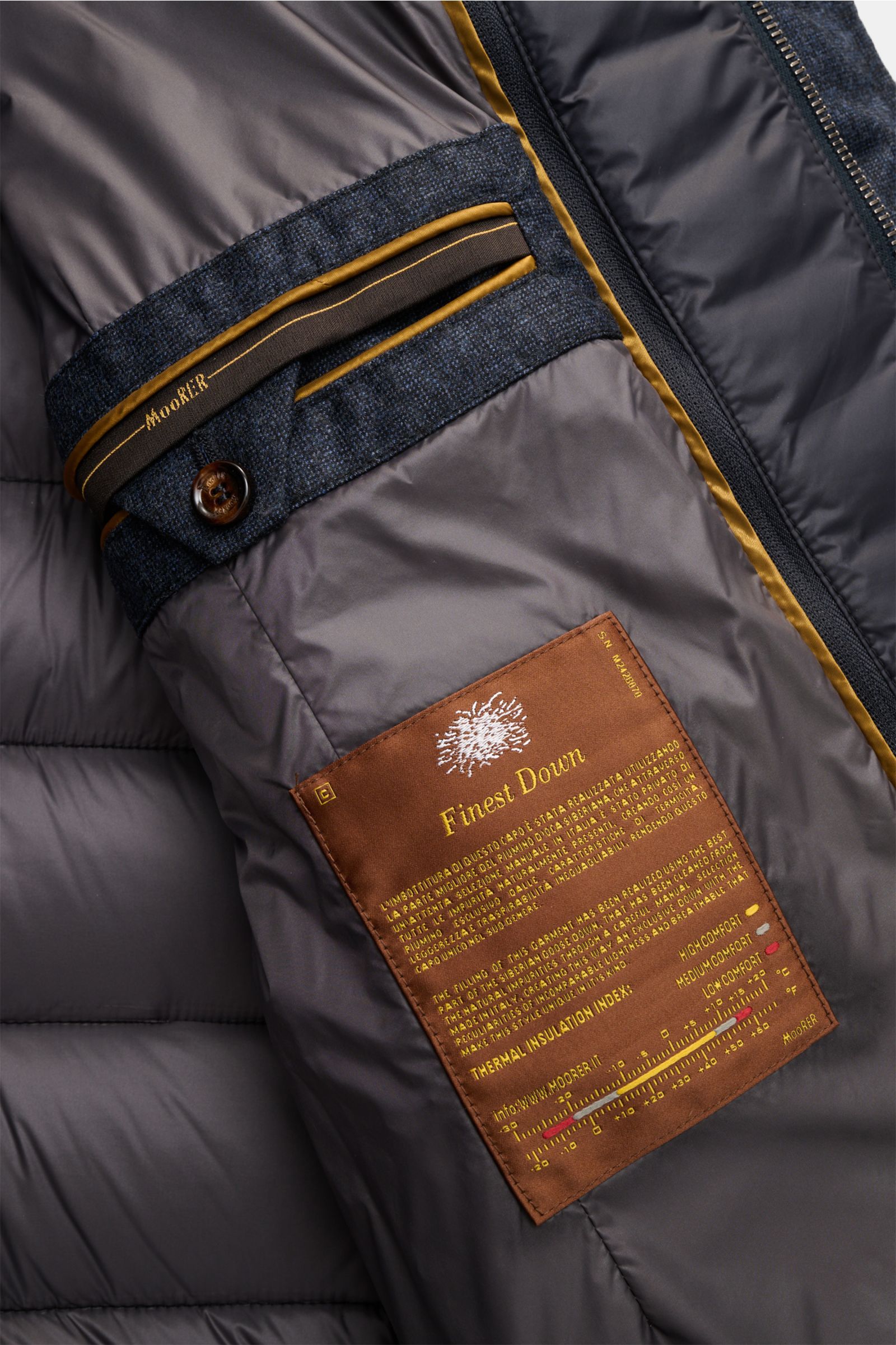 Nahaufnahme der Innenansicht der Moorer Daunenjacke 'Nomos' dark navy meliert mit herausnehmbarer Double-Front, Label und Zipper.