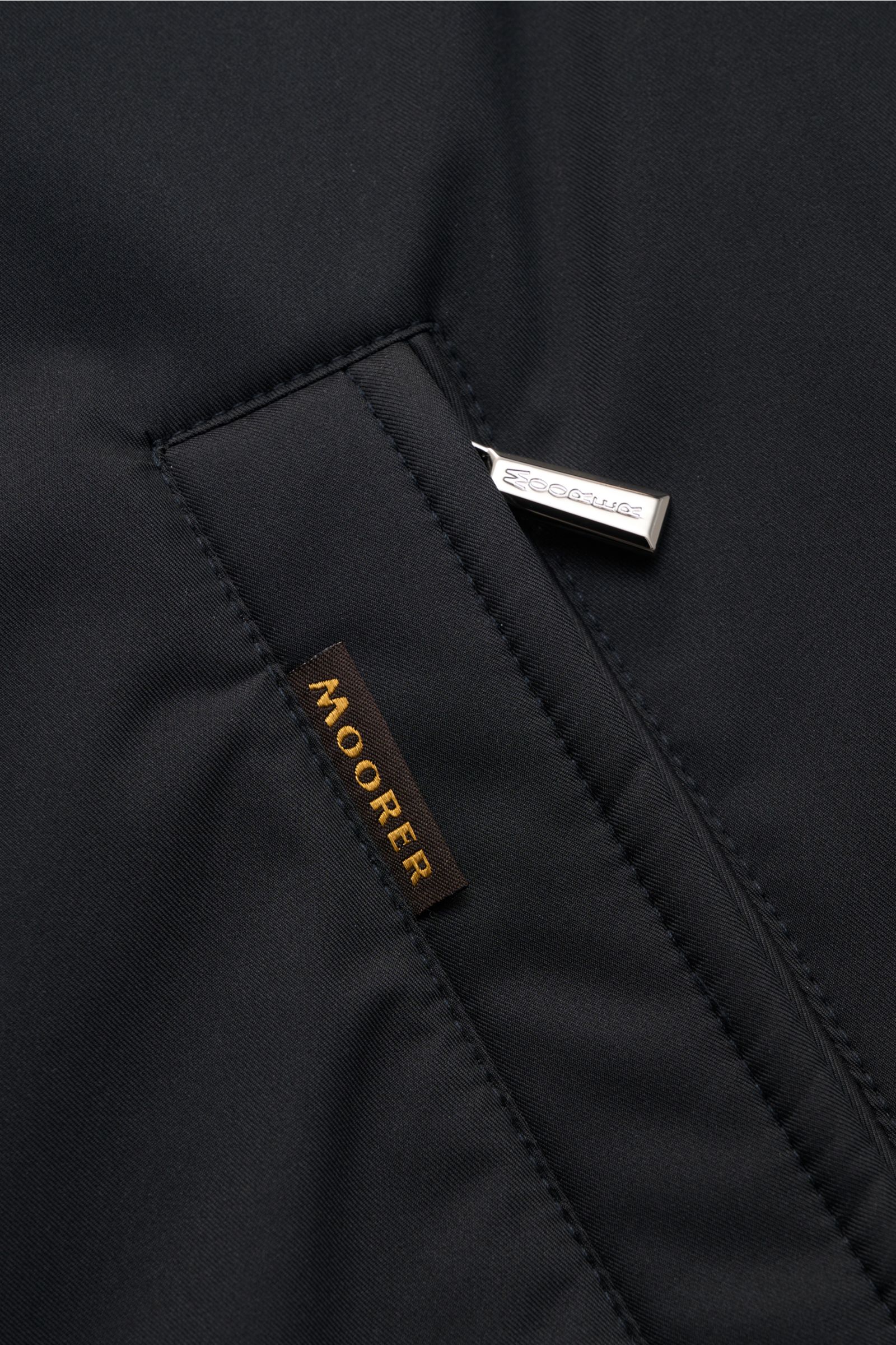 Nahaufnahme einer Reißverschluss-Fronttasche der Moorer Jacke 'Pericle' navy aus hochwertiger, wind- und wasserabweisender Microfaser.