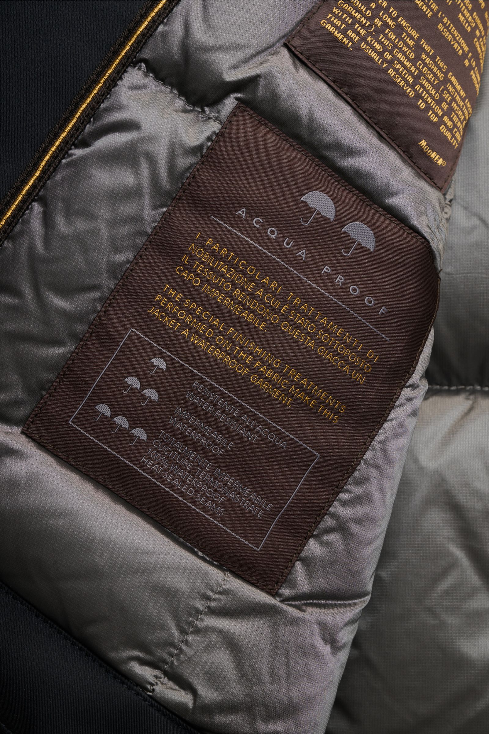 Nahaufnahme des Innenfutters der Moorer Jacke 'Pericle' navy mit wasserabweisendem Label und gesteppter Microfaser.