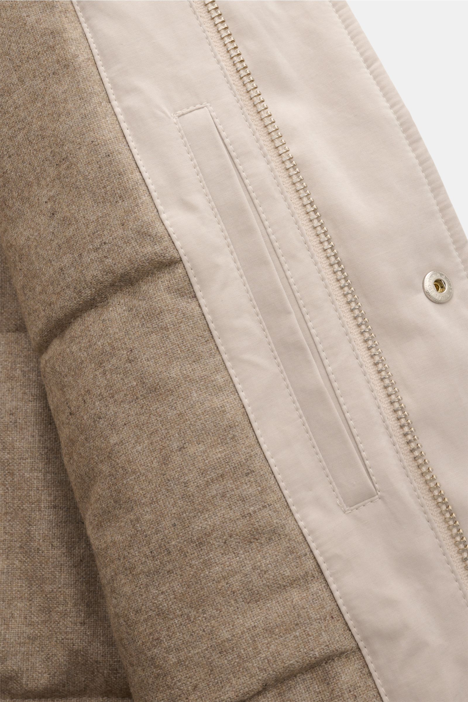 Close-up view of the 04651/ A trip in a bag Parka 'MC26' sand showing the lightly waxed cotton exterior, wool-mix lining, zipper, and pocket details.