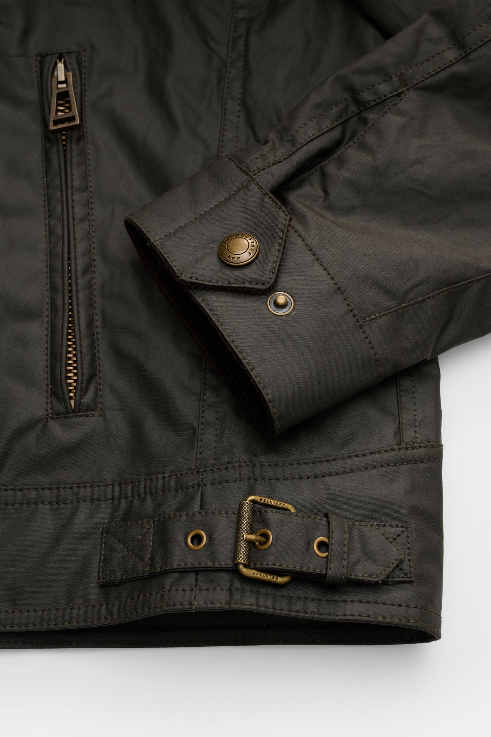 Belstaff Wachsjacke 'Racemaster' dark olive, Frontdetail mit robustem Metallreißverschluss, Brusttasche, Druckknopf-Manschette und Gürtel, Nahaufnahme.