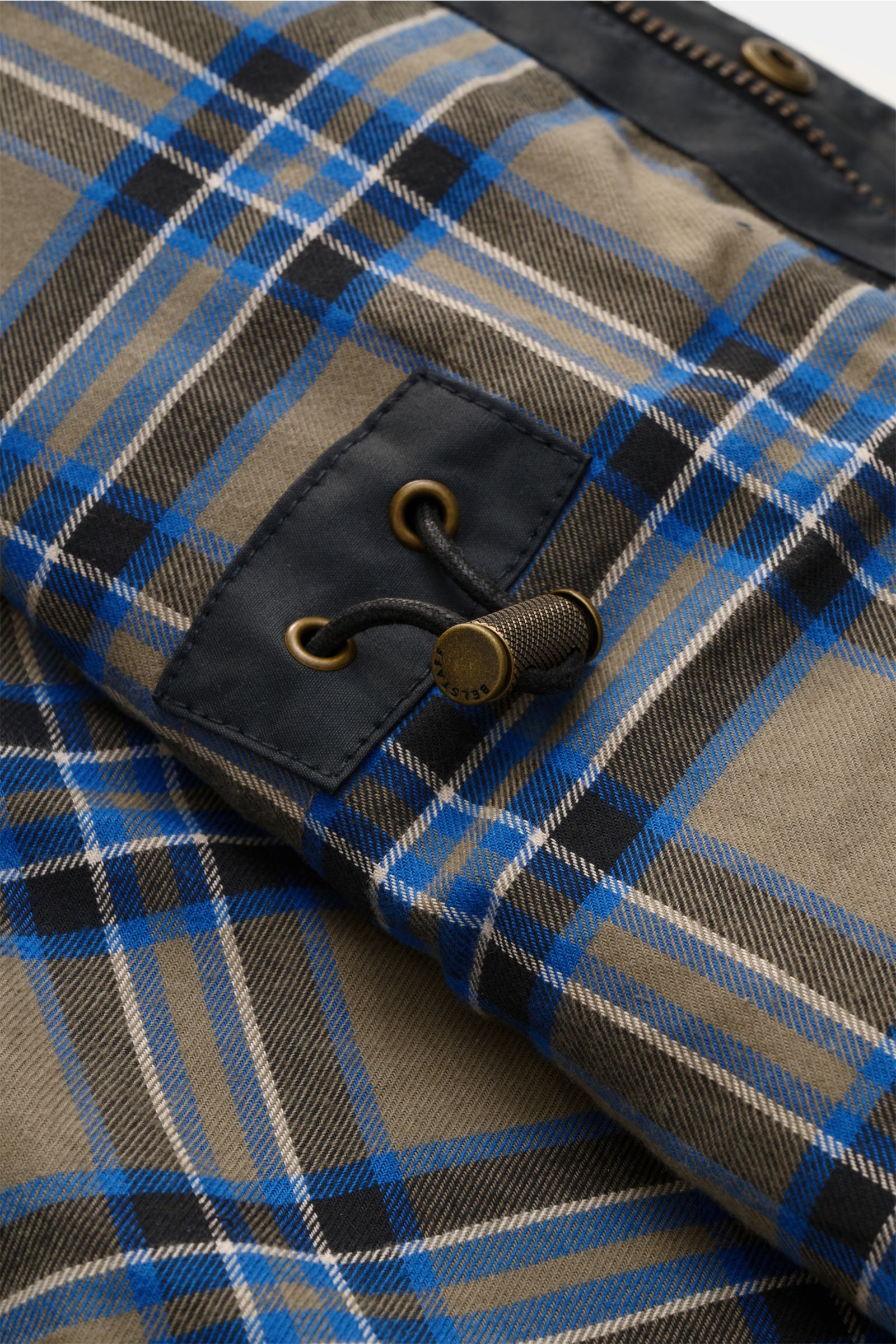 Nahaufnahme des karierten Innenfutters der Belstaff Wachsjacke 'Fieldmaster' dark navy mit Zugkordel und Metallösen, Detailansicht.
