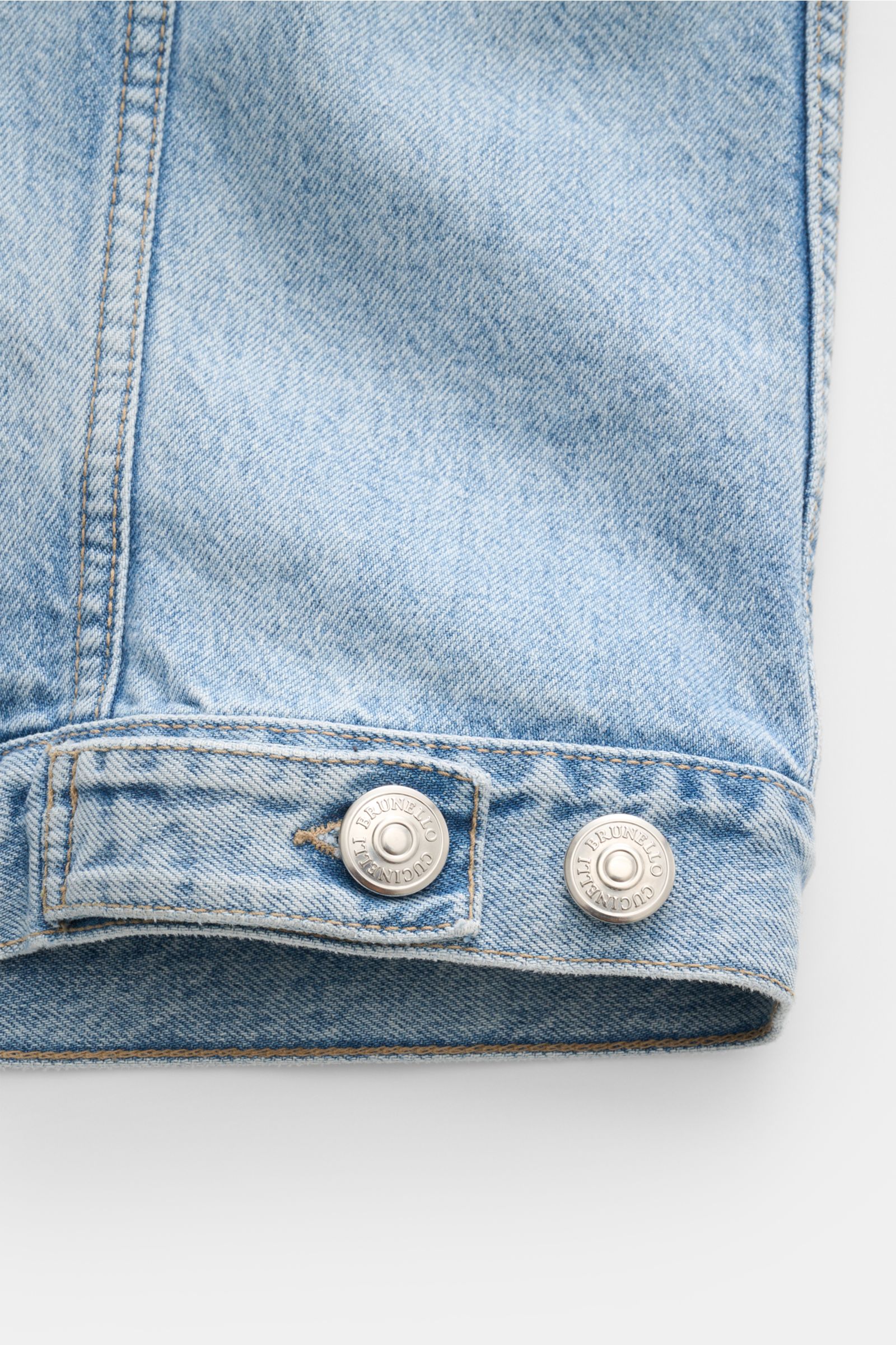 Close-up front view of Brunello Cucinelli Jeansjacke rauchblau cuff with silver branded buttons, pure cotton denim, soft touch, slim fit, suede collar trim, piped front pockets, six-button placket, and buttoned sleeve cuffs. Edles Casual-Piece: Die Jeansj