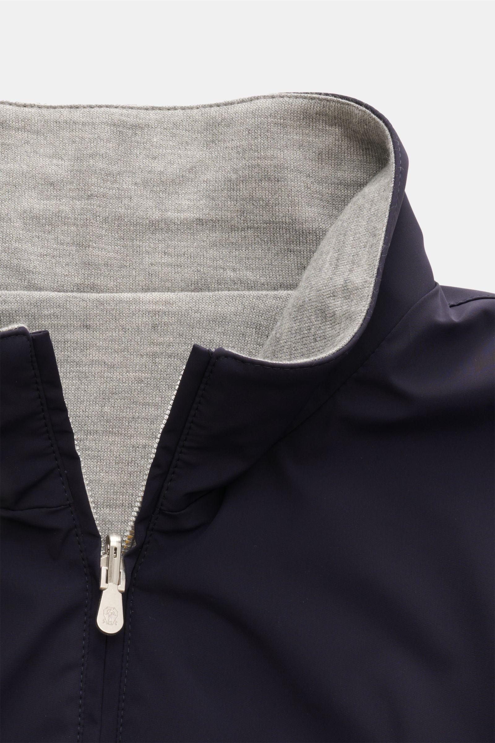 Close-up front view of the collar and zipper of the Brunello Cucinelli Wendeblouson navy/grau, showing the navy microfibre exterior and the grey cashmere-silk jersey interior, with a smooth texture and silver zipper detail. Zwei Looks, ein Anspruch: BR