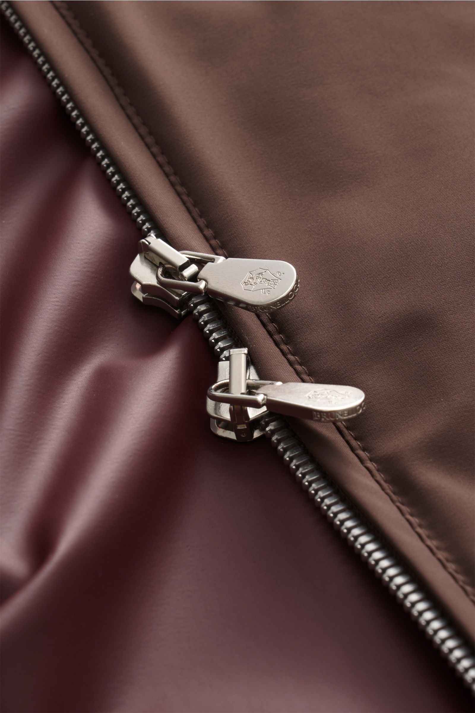 Close-up top view of the zipper and fabric detail of the Brunello Cucinelli Blouson grau meliert, showcasing the silk, linen, and wool mix with a three-dimensional woven texture and soft, slightly grainy feel.