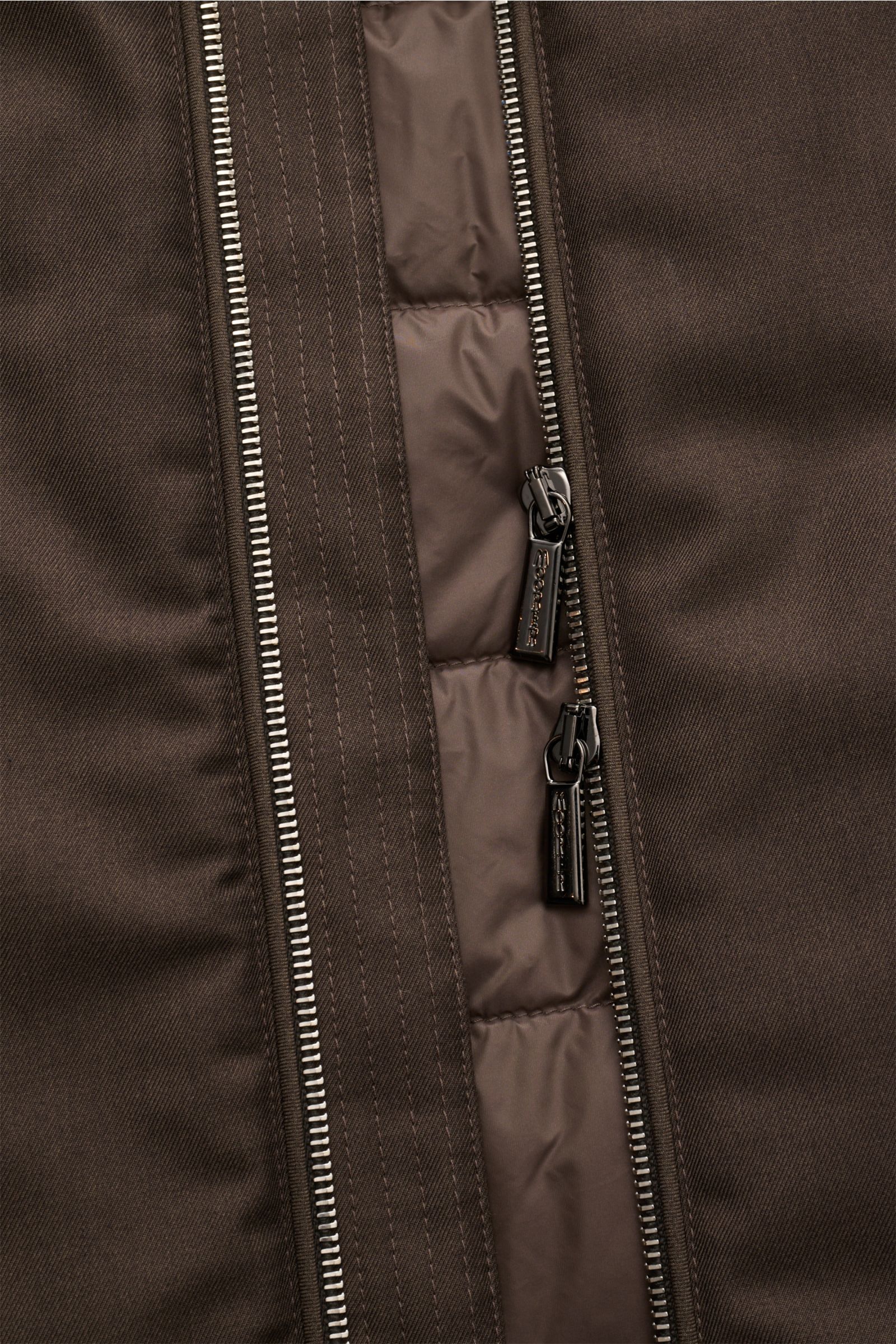 Moorer Daunenweste 'Uros' graubraun, Detailaufnahme des Zwei-Wege-Reißverschlusses aus edlem Garbadine-Gewebe, wind- und wasserabweisend, Slim Fit, weicher Griff.