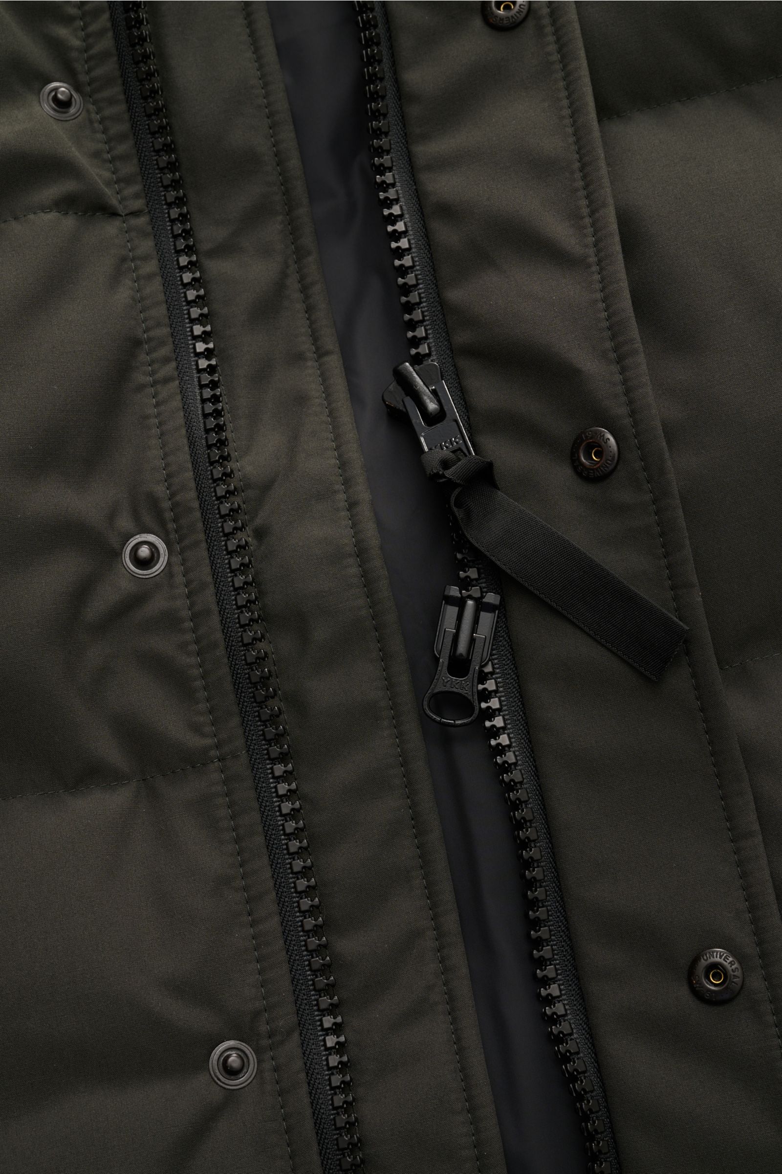 Nahaufnahme der Canada Goose Daunenweste 'Garson' graugrün von vorne mit offenem Zwei-Wege-Reißverschluss, Druckknöpfen und wasserabweisendem Baumwoll-Microfaser-Mix.