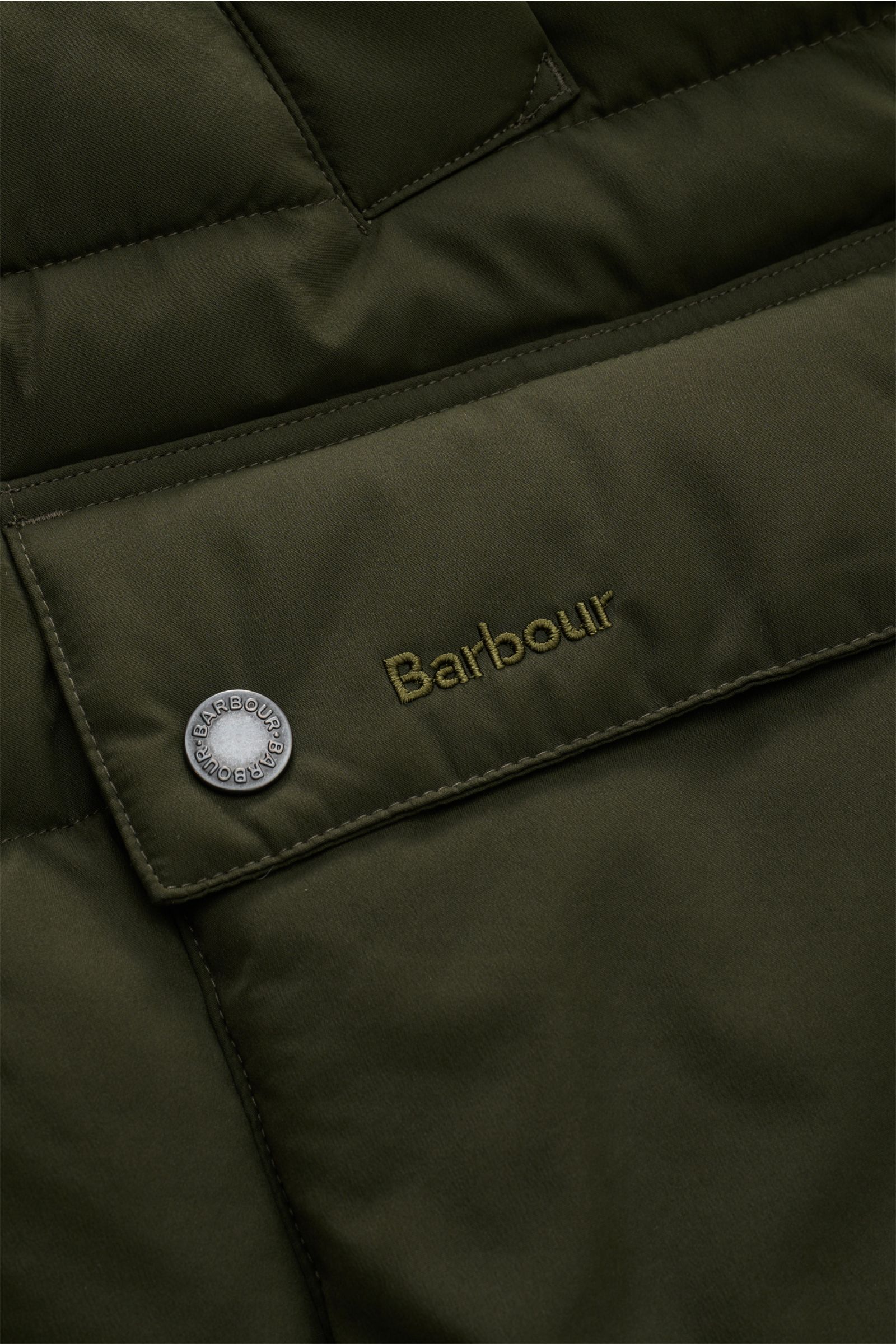 Nahaufnahme der dunkelgrünen Barbour Steppweste 'Bedale Puffer' mit Microfaser-Wattierung, Fronttasche, Druckknopf und Logo, von vorne.