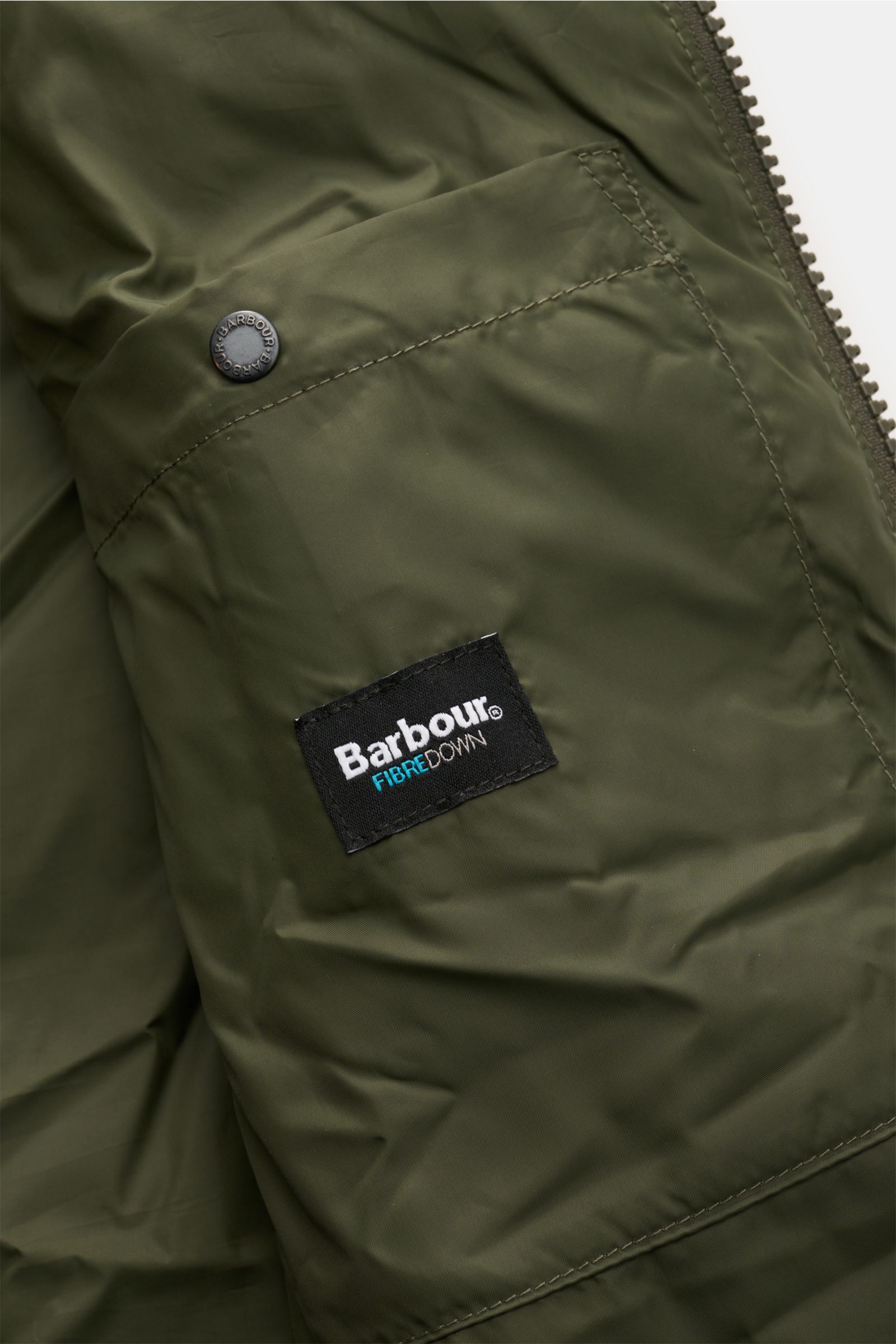Barbour Steppweste 'Bedale Puffer' dunkelgrün, Nahaufnahme der Innentasche mit Microfaser-Wattierung und Reißverschluss, glatter Griff.