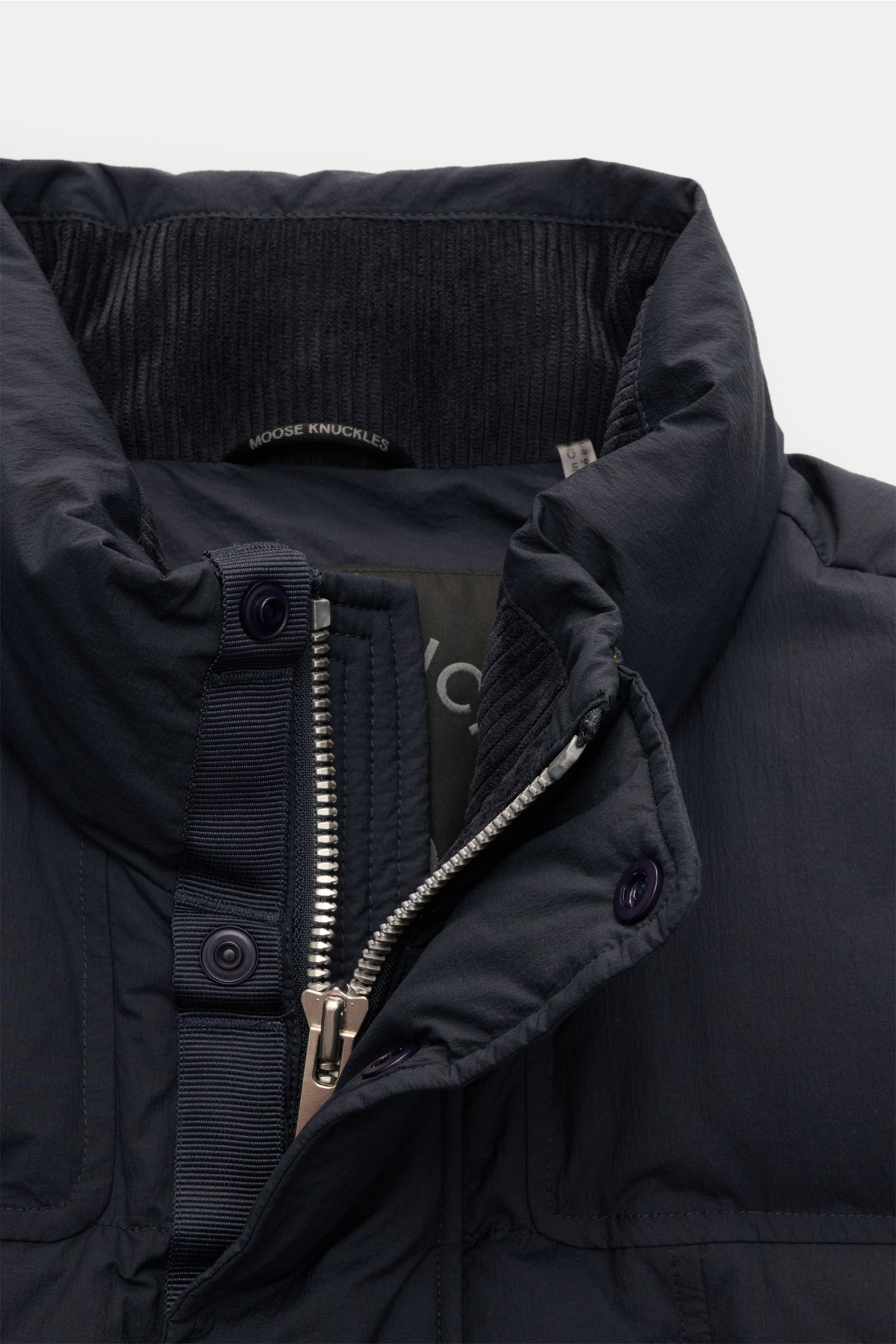 Close-up front view of the Moose Knuckles Daunenweste 'Everest' navy showing the padded stand-up collar, robust two-way zipper, snap button wind flap, and ribbed inner collar.

Legeres Outdoor-Essential: Die 'Everest' Daunenweste von MOOSE KNUCKLES kom