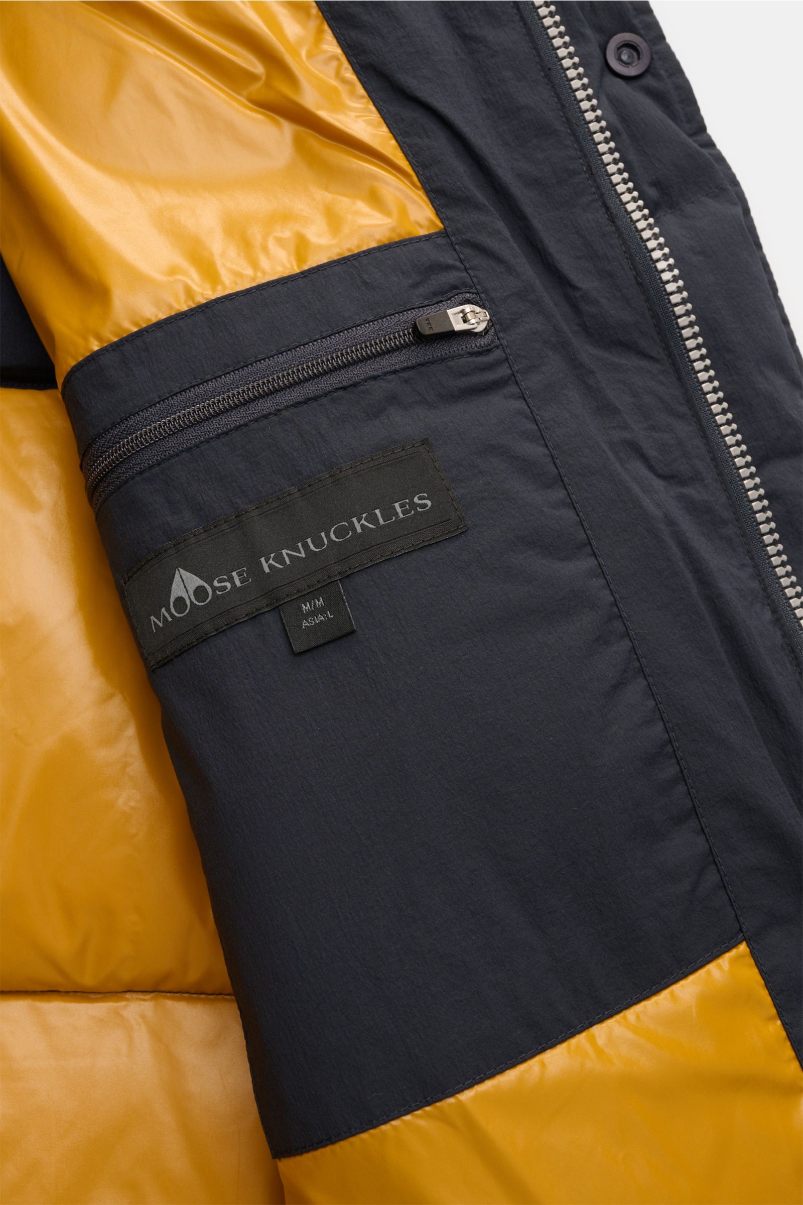Close-up inside view of Moose Knuckles Daunenweste 'Everest' navy showing inner zip pocket with logo, highlighting fabric and zipper details.

Legeres Outdoor-Essential: Die 'Everest' Daunenweste von MOOSE KNUCKLES kombiniert funktionale Isolation mit 
