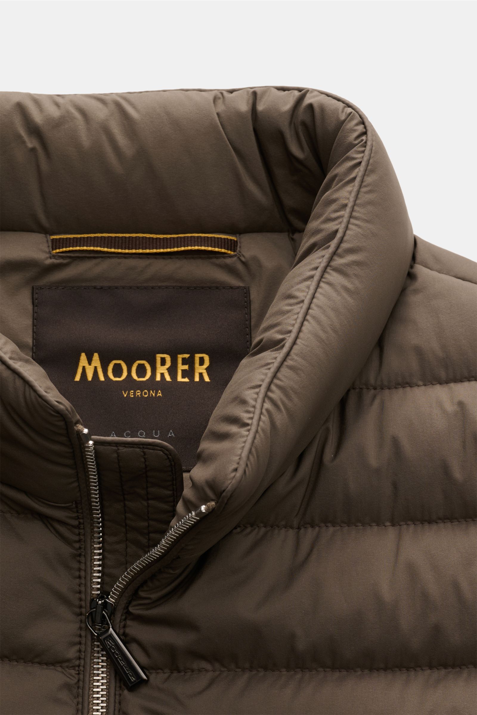 Close-up front view of Moorer Daunenweste 'Calaf' dark olive with padded collar, two-way zipper, and quilted microfiber fabric.

Luxus in allerhöchster Qualität: Feinste sibirische Gänsedaunen werden für die gesteppte Outdoor-Weste 'Calaf' von MOORER h