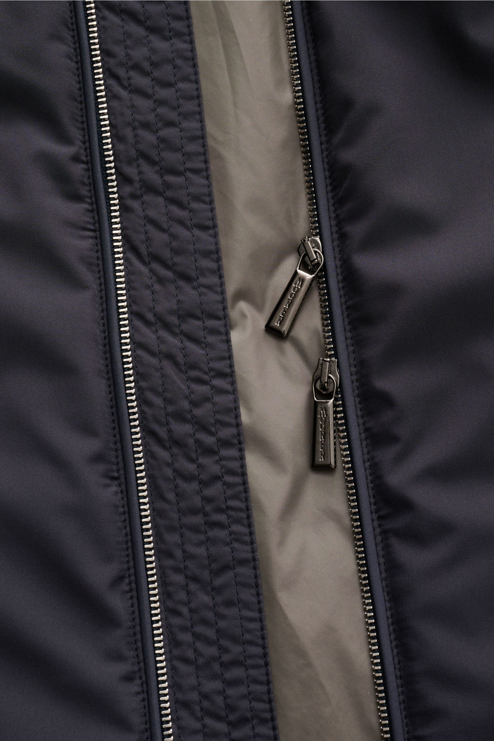 Nahaufnahme von zwei Reißverschlüssen der Moorer Outdoor-Weste 'Senio-Skt' dark navy, wasserabweisend, Slim Fit, mit Innentasche.
