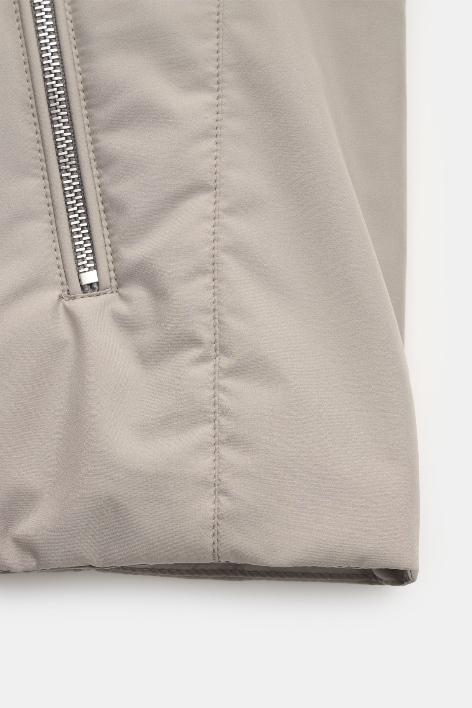 Close-up front view of the beige Moorer Outdoor-Weste 'Senio-Skt', showing water-repellent microfiber fabric, slim fit, two-way zipper, angled zip front pocket, narrow stand-up collar, light filling, and smooth texture. Die leichte Outdoor-Weste 'Senio
