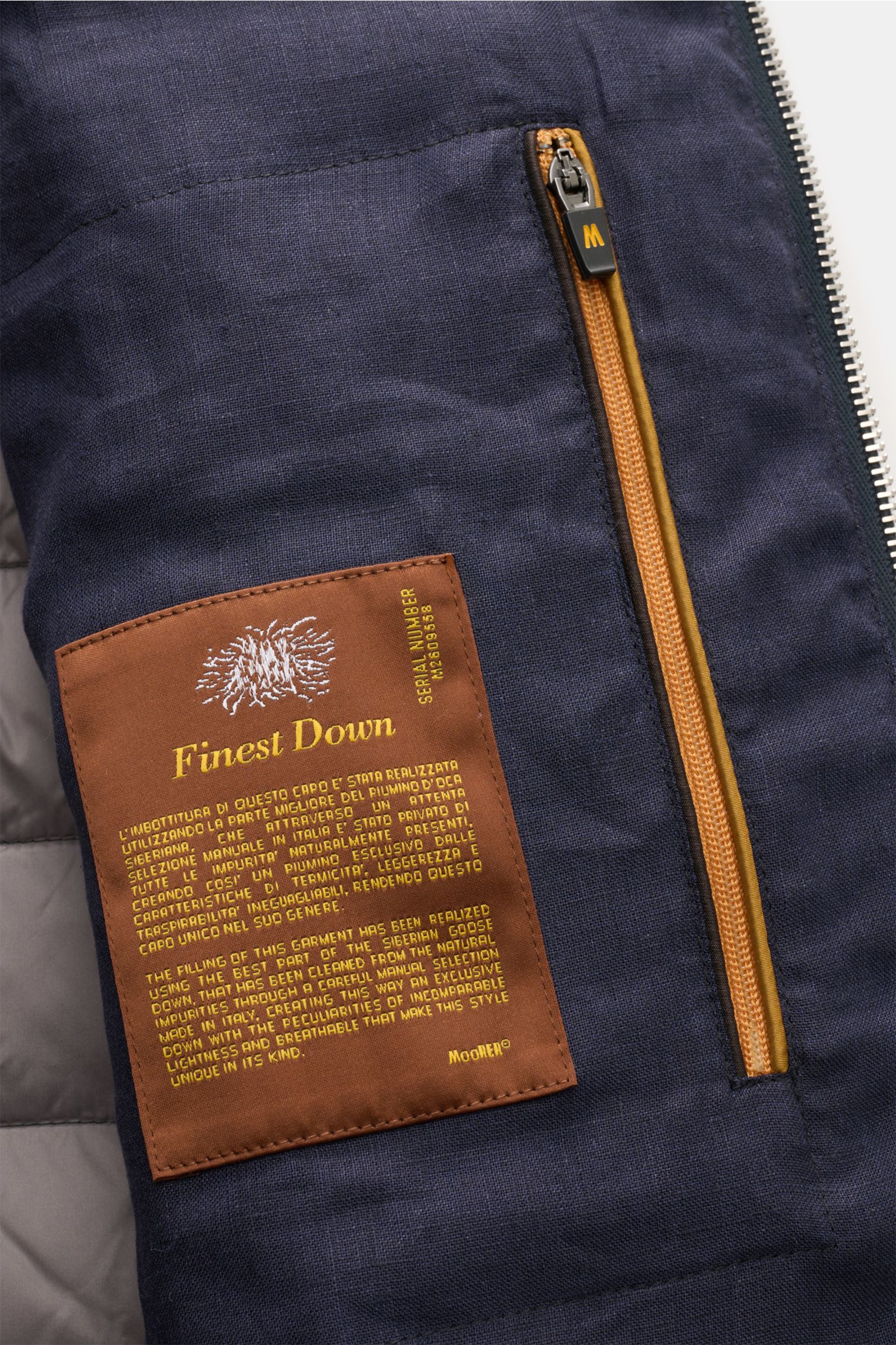 Close-up interior view of the Moorer Down gilet 'Calaf' navy mottled showing a brown Finest Down label and an orange zip pocket.

Luxury of the very highest quality: Only the finest, hand-selected Siberian goose down is used for the quilted outdoor gil