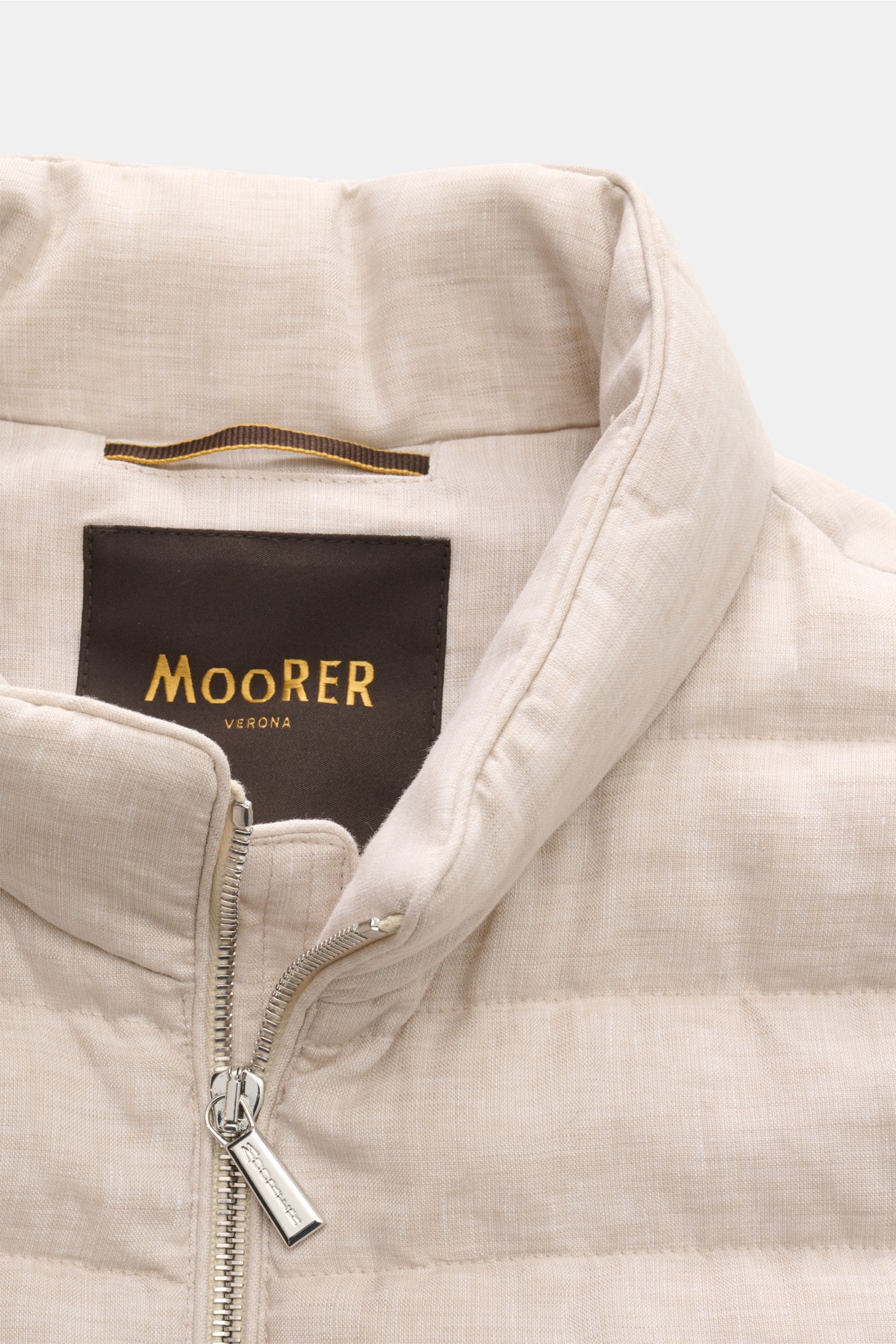 Close-up front view of the Moorer Down gilet 'Calaf' beige mottled, showing narrow cross quilting, slim standing collar, and two-way silver zip.

Luxury of the very highest quality: Only the finest, hand-selected Siberian goose down is used for the qui