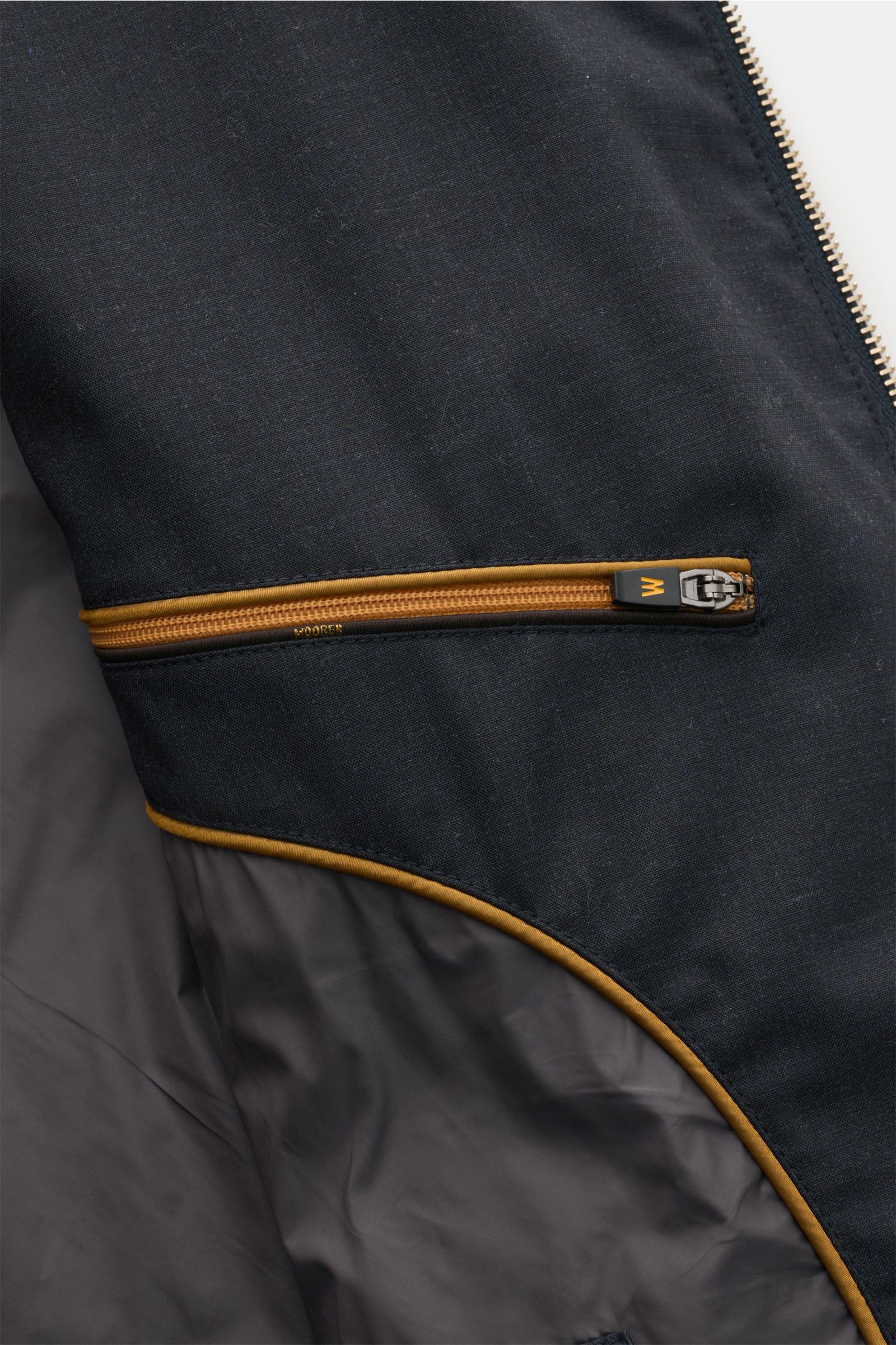 Nahaufnahme der Innenansicht der Moorer Outdoor-Weste 'Senio-Bt' dark navy mit elastischer Schurwolle, Reißverschluss-Innentasche und glattem Griff.