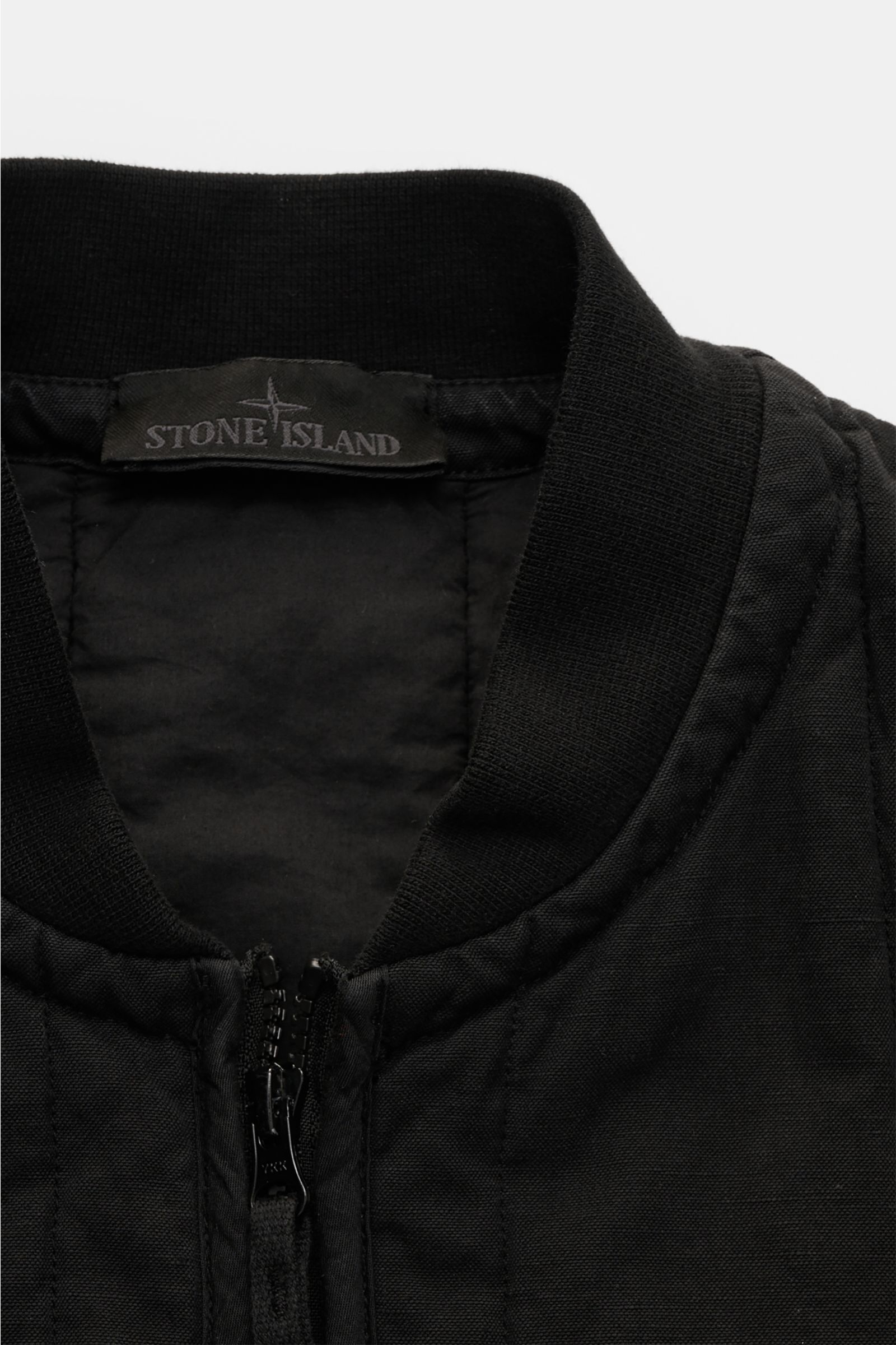 Stone Island Outdoorweste 'Ghost Piece' schwarz, Slim Fit, Baumwolle-Leinen-Mix, Blousonkragen, Zweifach-Reißverschluss, Nahaufnahme von oben.