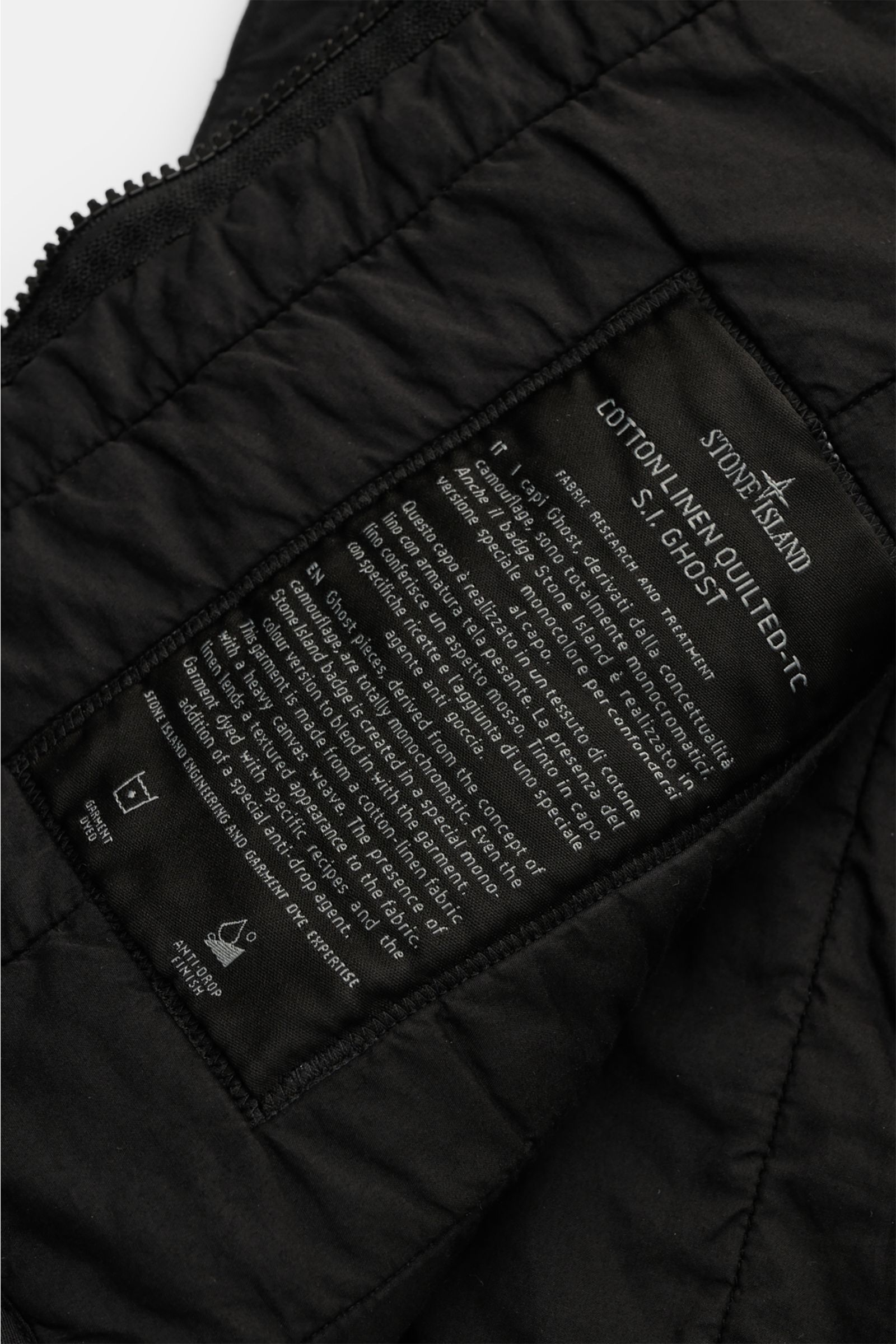 Nahaufnahme des Innenetiketts der Stone Island Outdoorweste 'Ghost Piece' schwarz aus Baumwolle und Leinen mit Slim Fit und Blousonkragen.