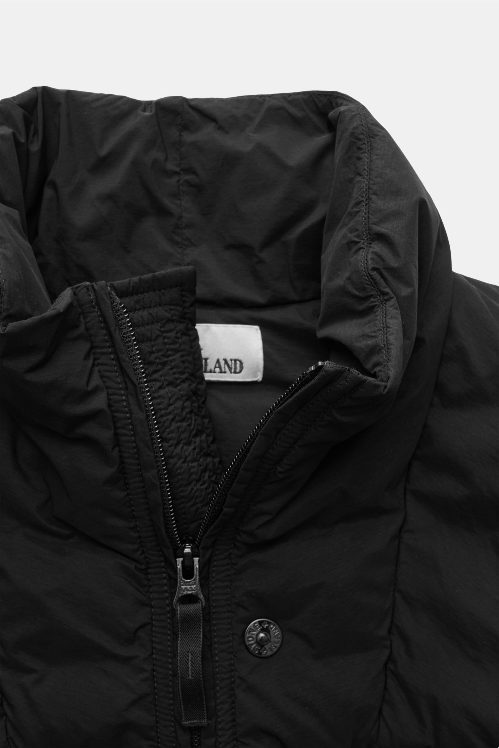 Stone Island Daunenweste 'Seamless Tunnel Nylon Down-TC' schwarz shown from a close-up front angle, highlighting the high collar, two-way zipper, and textured fabric. Die Outdoorweste 'Seamless Tunnel Nylon Down-TC' von STONE ISLAND überzeugt mit leich