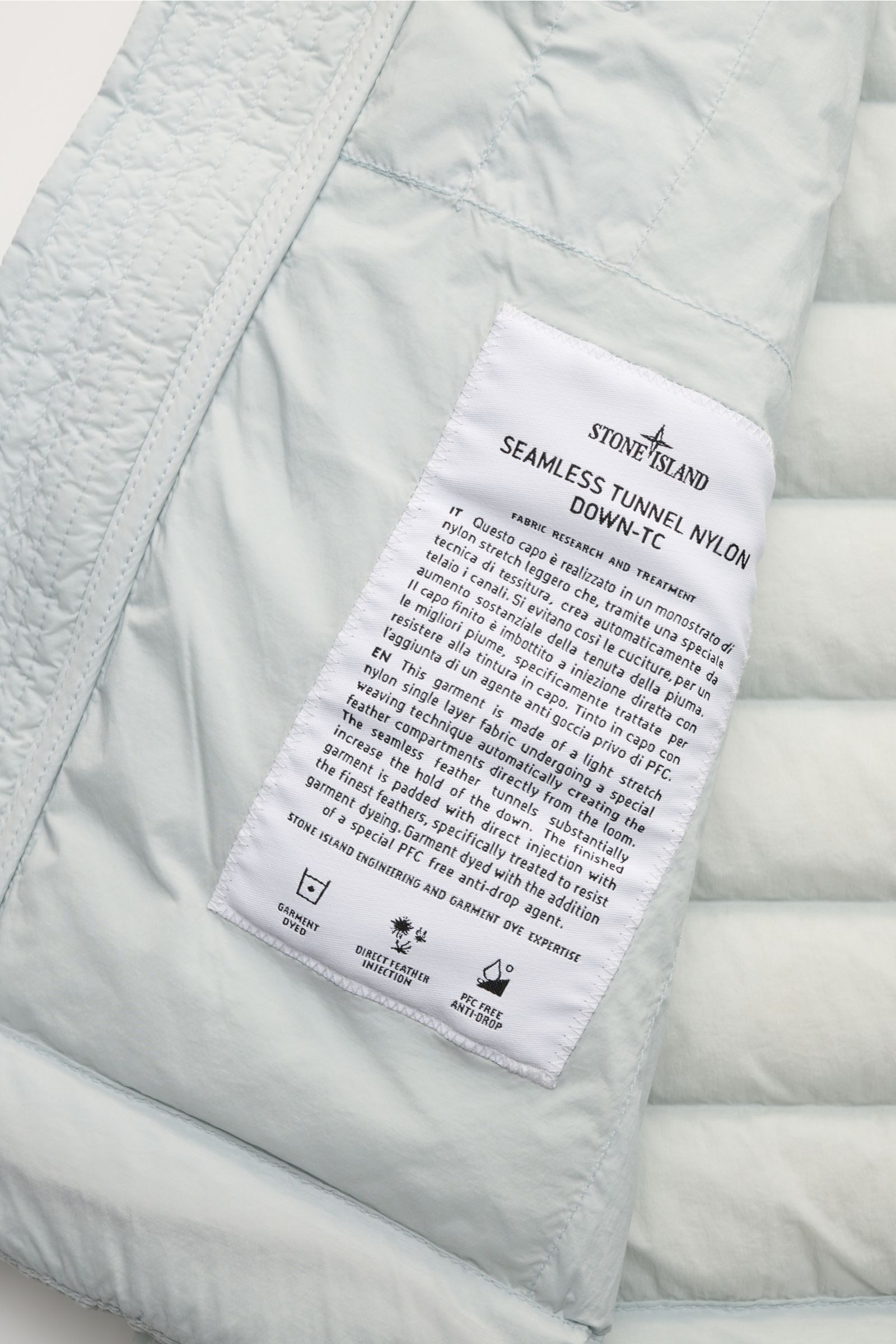 Stone Island Daunenweste 'Seamless Tunnel Nylon Down' hellgrau, Detailaufnahme Innenlabel, elastisches, wind- und wasserabweisendes Gewebe, leichte Daunenfüllung.