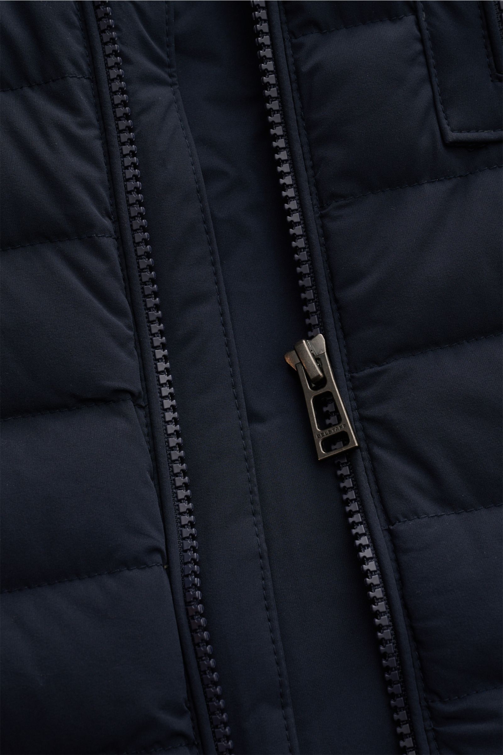 Close-up front view of Belstaff Daunenweste 'Chassis' navy showing water-repellent microfibre, smooth texture, robust zipper.  
Unverzichtbares Outdoor-Must-have im lässigen BELSTAFF-Stil: Die Daunenweste 'Chassis' bietet uneingeschränkte Funktionalitä