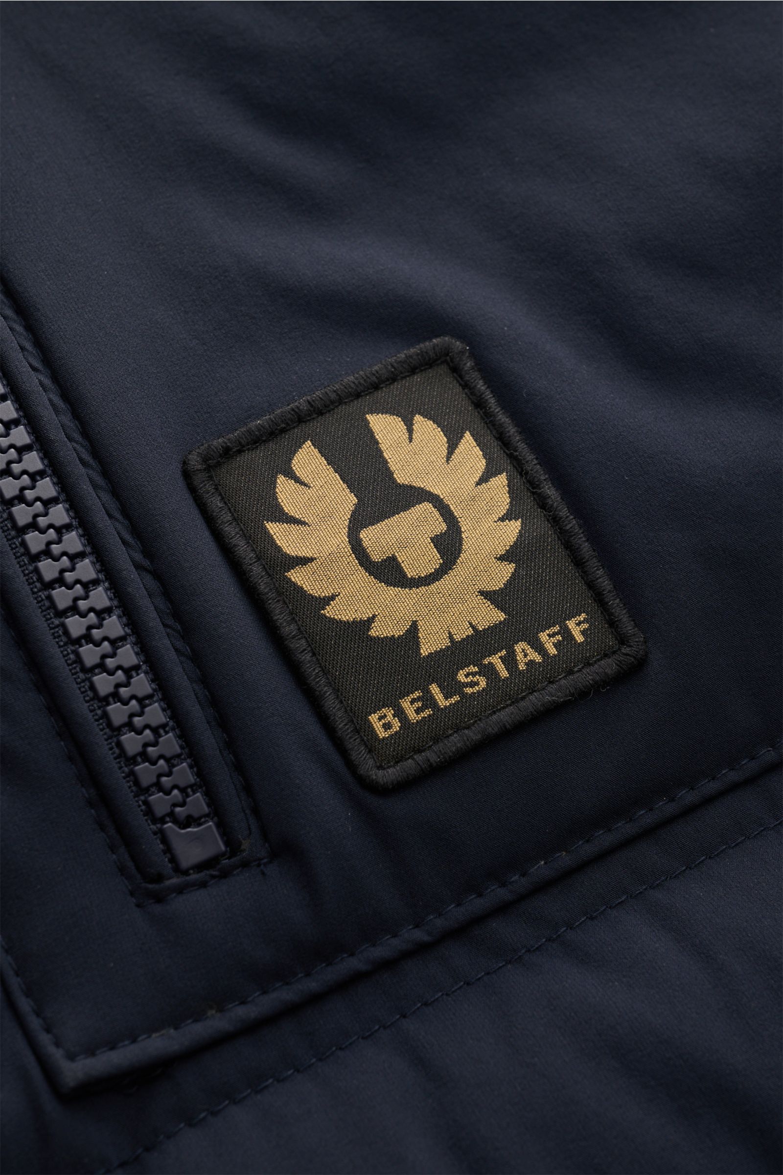 Close-up front view of the Belstaff Daunenweste 'Chassis' navy showing the BELSTAFF-Weblabel and a robust zipper on smooth, water-repellent microfiber.

Unverzichtbares Outdoor-Must-have im lässigen BELSTAFF-Stil: Die Daunenweste 'Chassis' bietet unein
