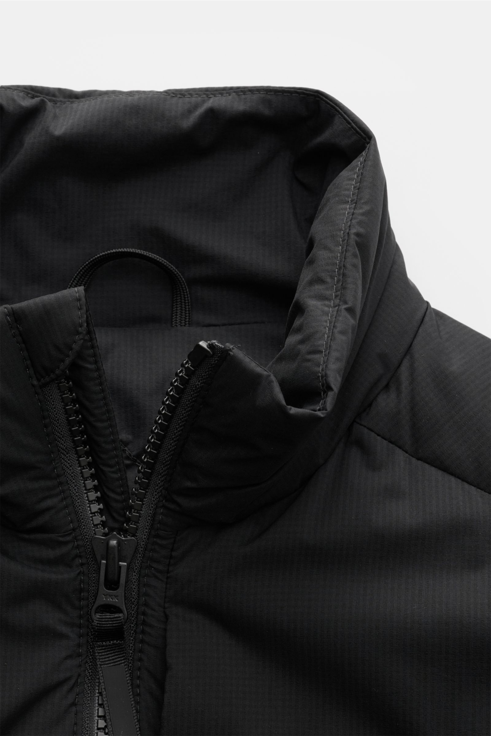 Canada Goose Daunenweste 'Lodge' schwarz, Nahaufnahme von Stehkragen und Zwei-Wege-Reißverschluss aus Ripstop-Microfaser, Slim Fit, wind- und wasserabweisend, leichte Daunenfüllung.