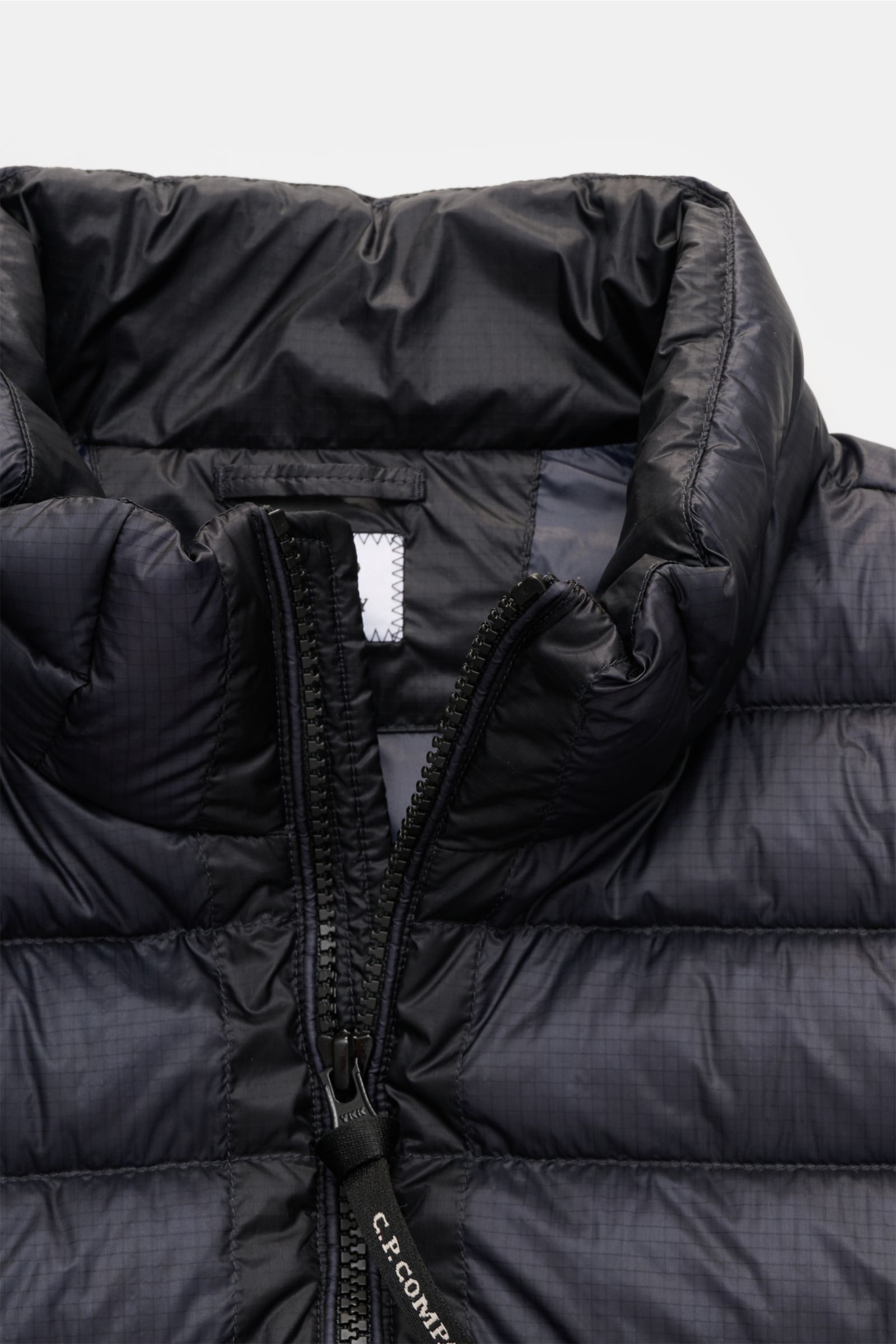 Close-up front view of the C.P. Company Daunenweste 'D.D. Shell' dark navy, showing the padded collar, robust two-way zipper with branded pull, and smooth ripstop microfiber fabric. Die Konstruktion der Daunenweste 'D.D. Shell' von C.P. COMPANY zeichnet s